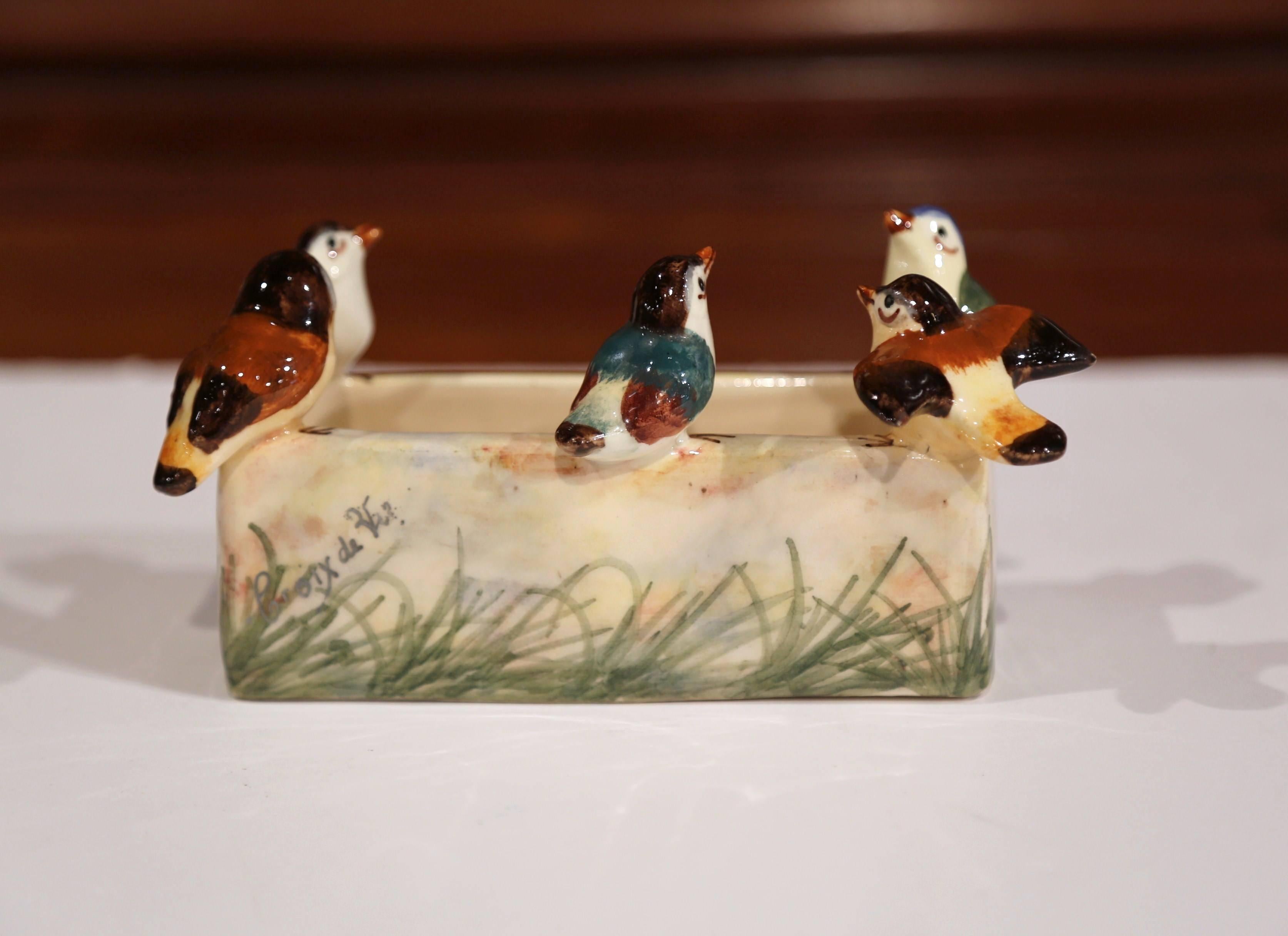 Cette jardinière en porcelaine ancienne et colorée a été fabriquée à Vallauris, en France, vers 1880. Le plat rectangulaire ludique est surmonté sur le pourtour de cinq figures d'oiseaux en haut-relief. La petite jardinière en céramique est en
