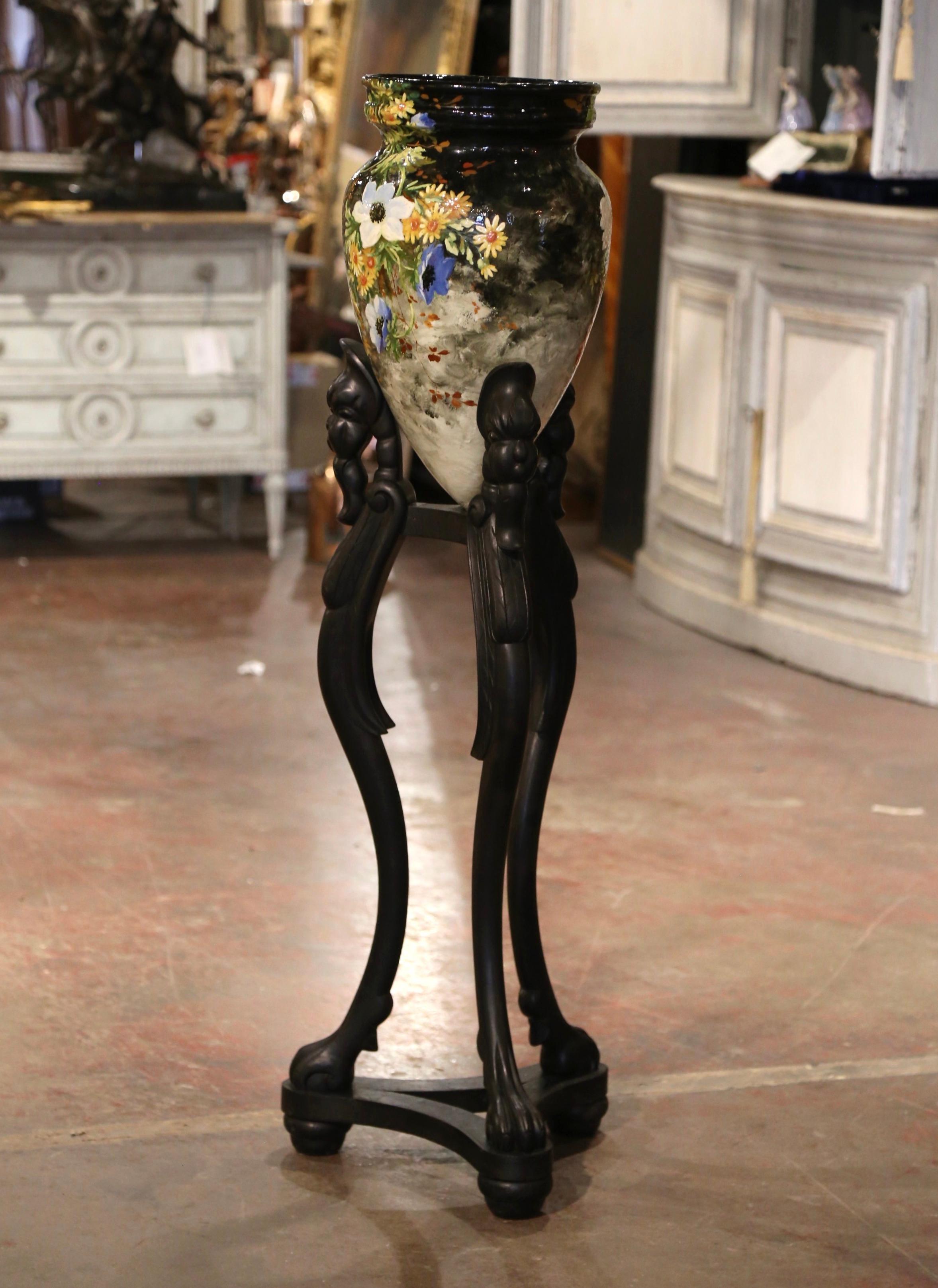 Questa colorata urna in maiolica a due pezzi con base è stata scolpita a Montigny sur Loing, in Francia, intorno al 1860. Alta e di forma ovale, la jardinière in ceramica poggia su una base a treppiede in legno intagliata a mano con gambe a cabriole