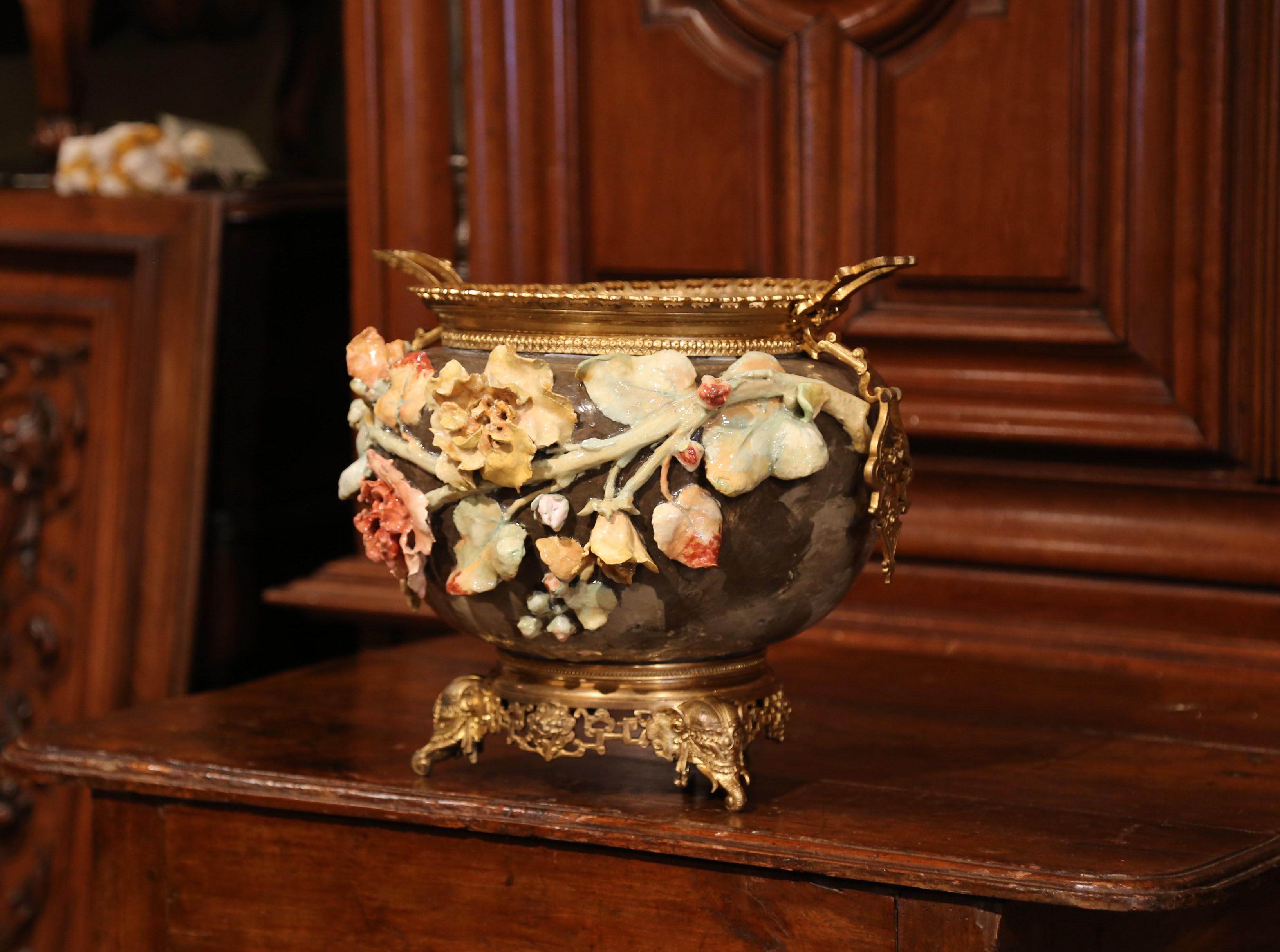 Embellish your home with this elegant antique, hand-painted Majolica planter from Montigny sur Loing, France. Sculpted circa 1860, the ornate jardinière sits on a bronze base embellished by four decorative oriental elephant trunk feet. You'll also