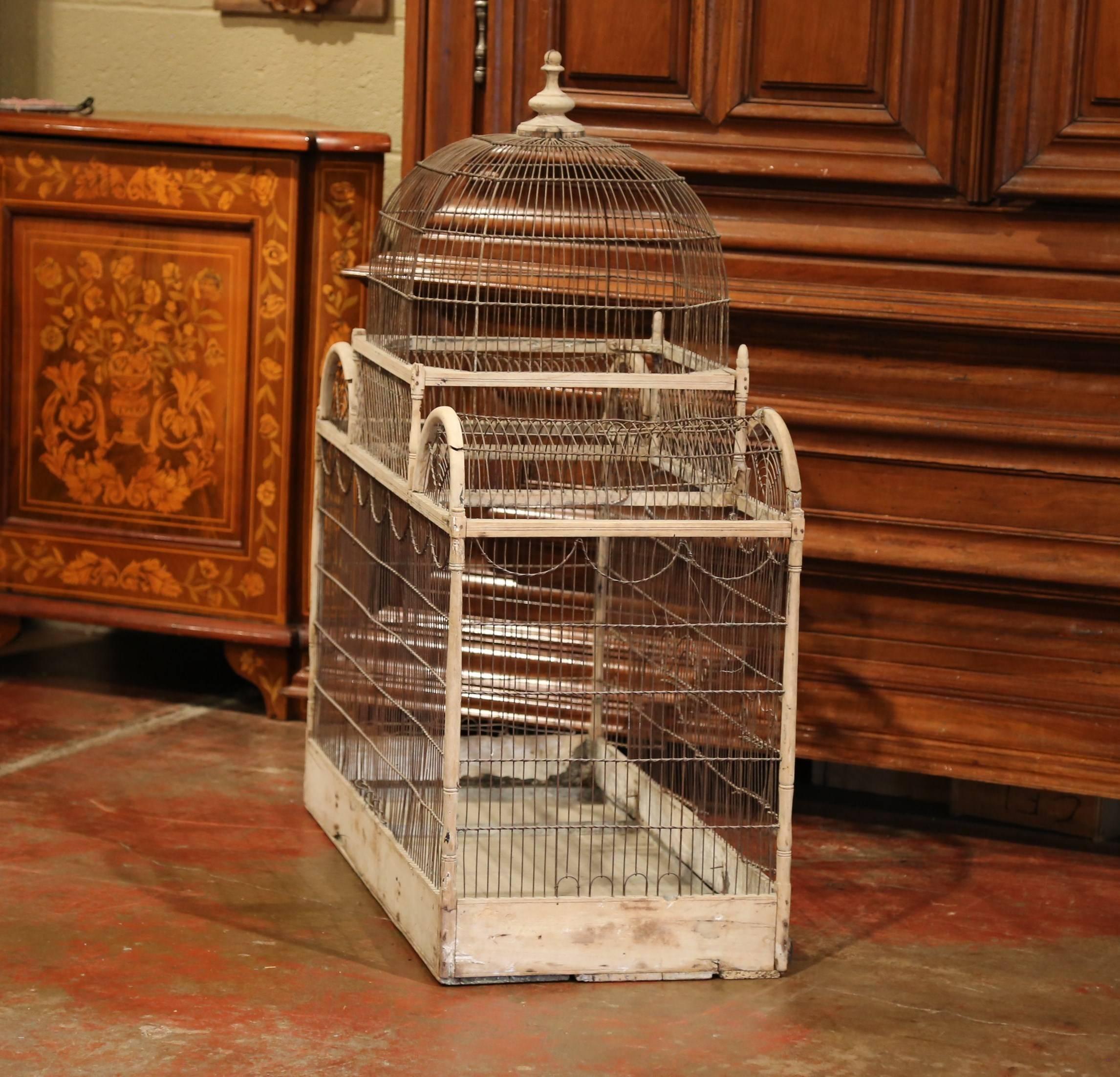 Bring the outdoors in with this large, elegant, antique birdcage. Crafted in France, circa 1860, this hand painted cage features a rounded dome top with a decorative finial, two demilune arches on each side and a larger rectangular birdhouse
