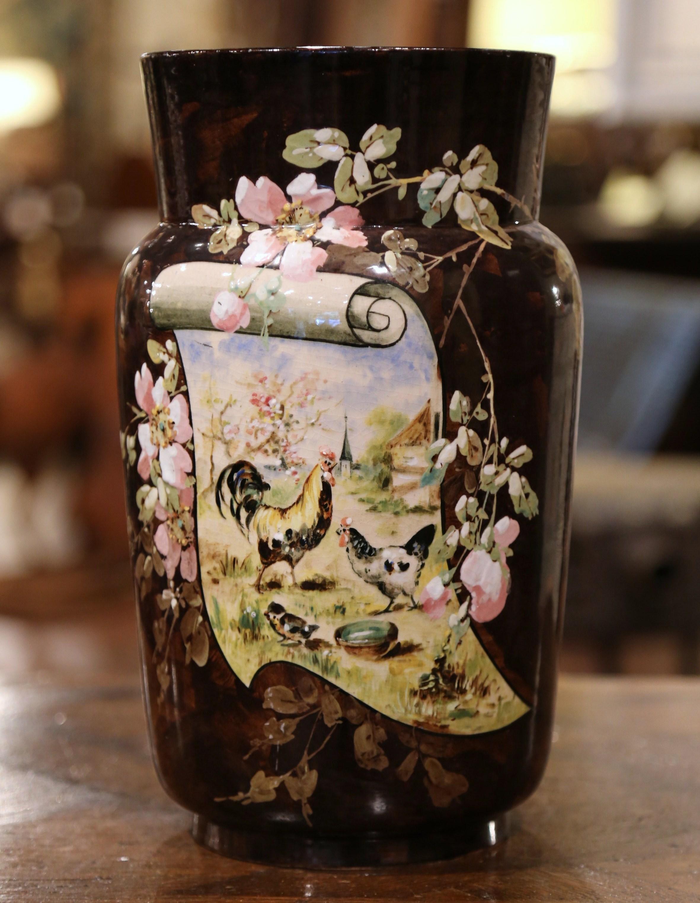 Ce grand vase ancien peint à la main a été créé en France vers 1865. Réalisé en majolique, ce vase coloré représente une scène peinte à la main avec un coq et une poule, agrémentée de motifs floraux sur le fronton et les deux côtés. L'élégant vase