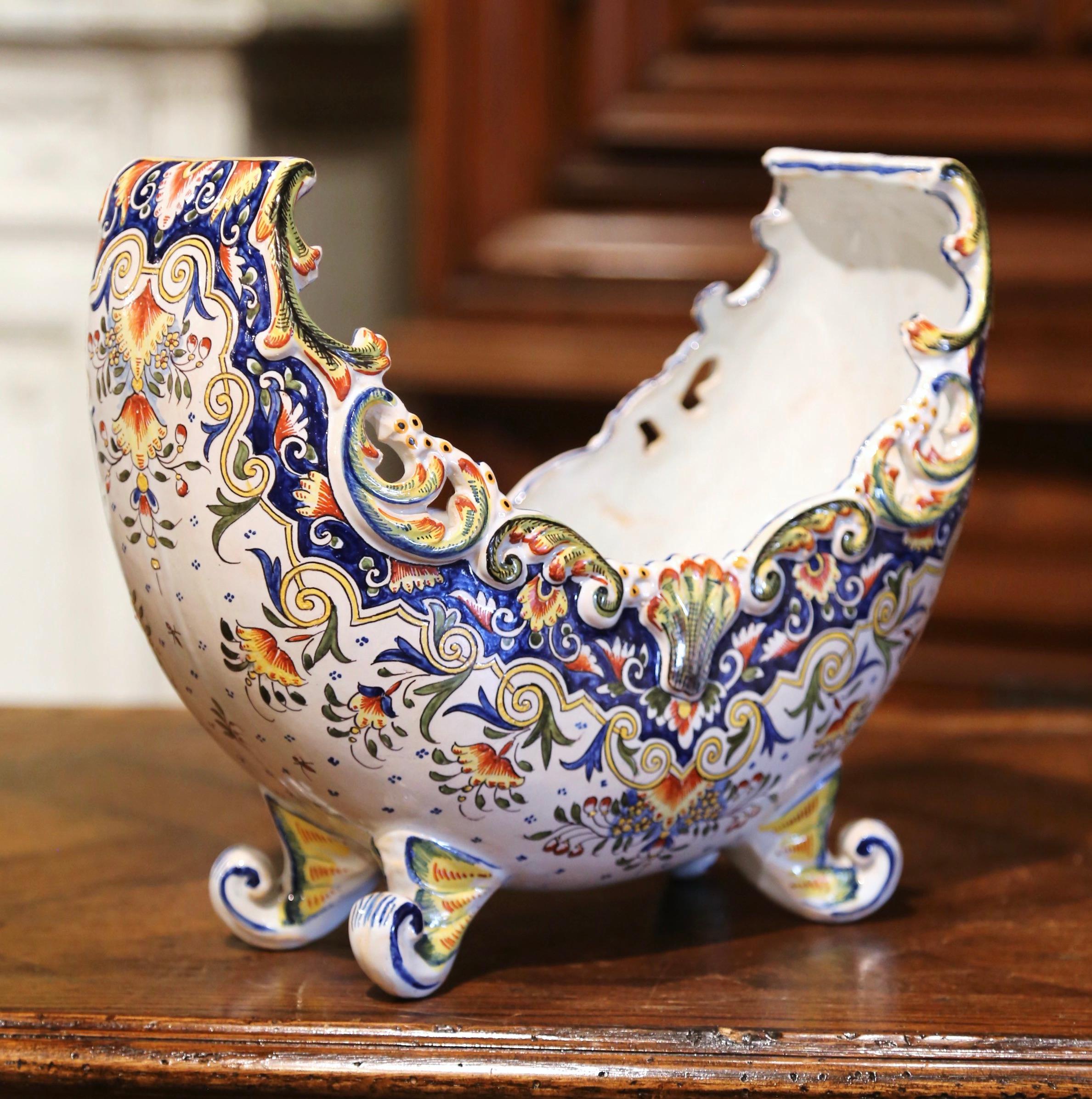 Crafted in Rouen, France circa 1890, the antique ceramic planter shaped as a half moon, sits on four scroll feet; it features tall curved sides, a scalloped rim at the top embellished with a carved decorative shell in the center and pierced leaves