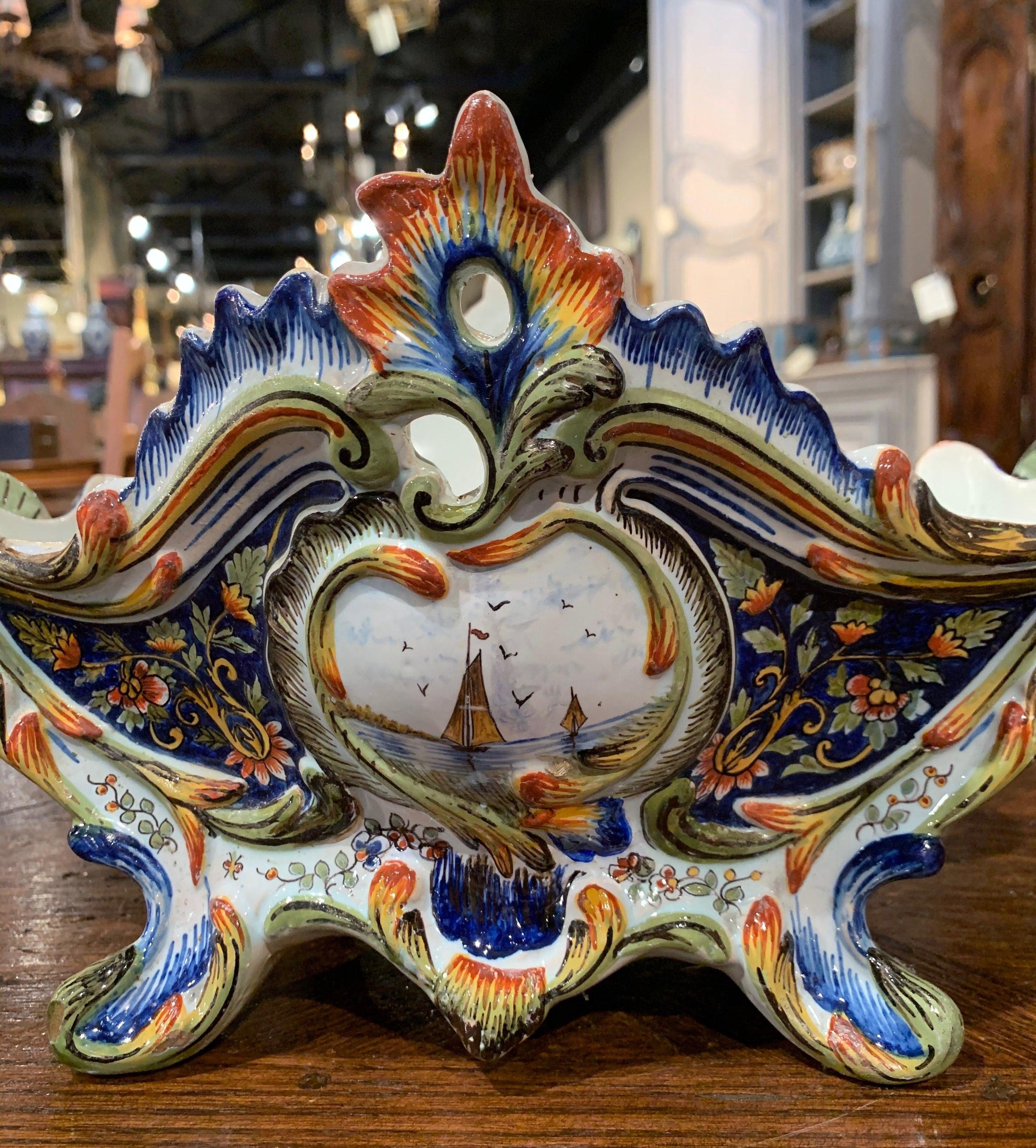 Fabriquée à Rouen, en France, vers 1890, de forme ovale, cette jardinière antique repose sur des pieds à volutes au-dessus d'un tablier festonné ; elle présente d'élégantes poignées latérales, un rebord percé autour du sommet agrémenté de motifs de
