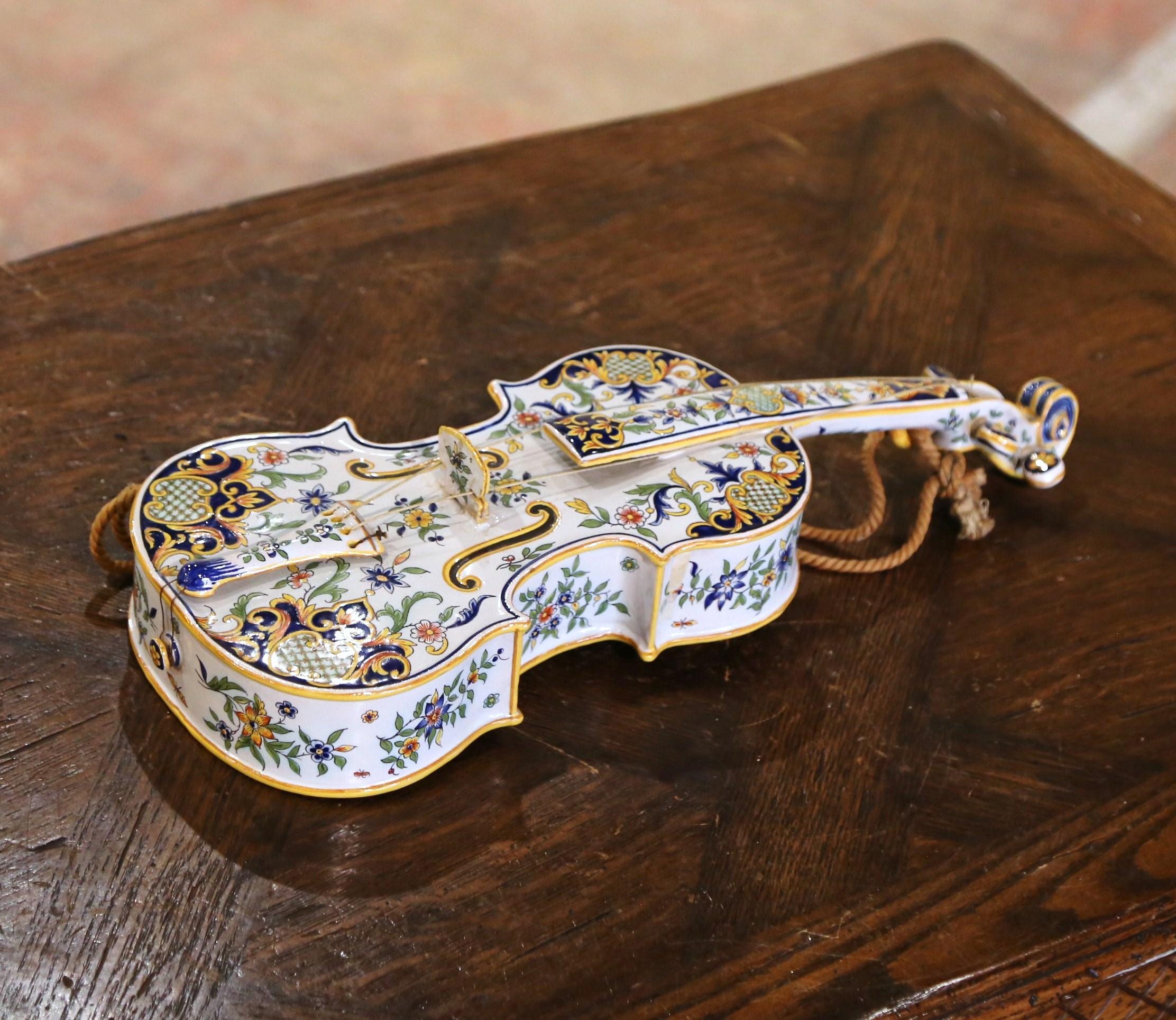 Decorate a wall with this interesting and colorful antique ceramic violin shape letter holder; crafted in the Normand city of Rouen, France, circa 1880, the colorful barbotine music instrument features hand painted floral decor in the traditional