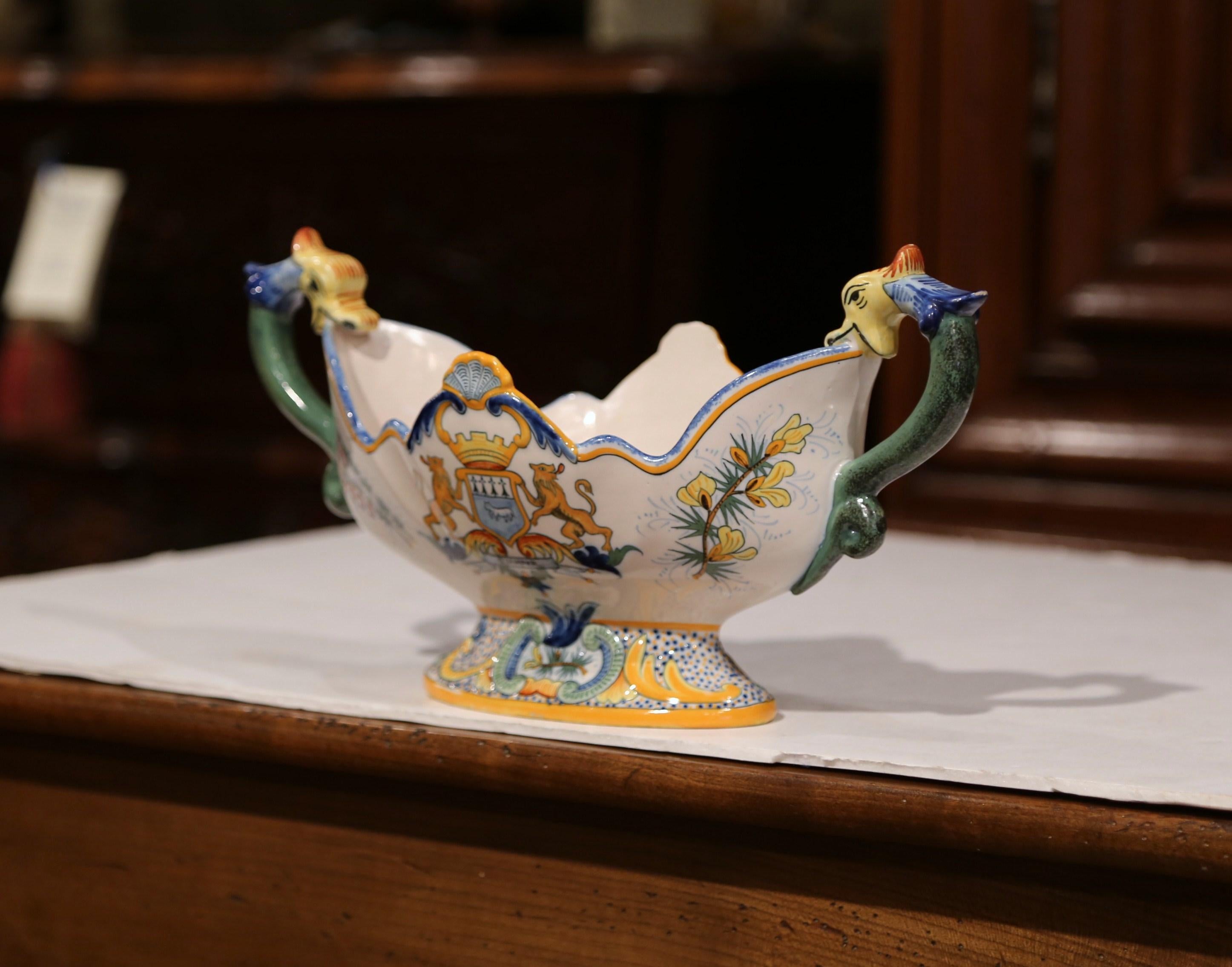 This antique ceramic planter was crafted in Brittany, France, circa 1870. Oval in shape, the colorful jardinière has two elegant side handles and features hand painted decoration throughout. The painted elements include a traditional Breton couple
