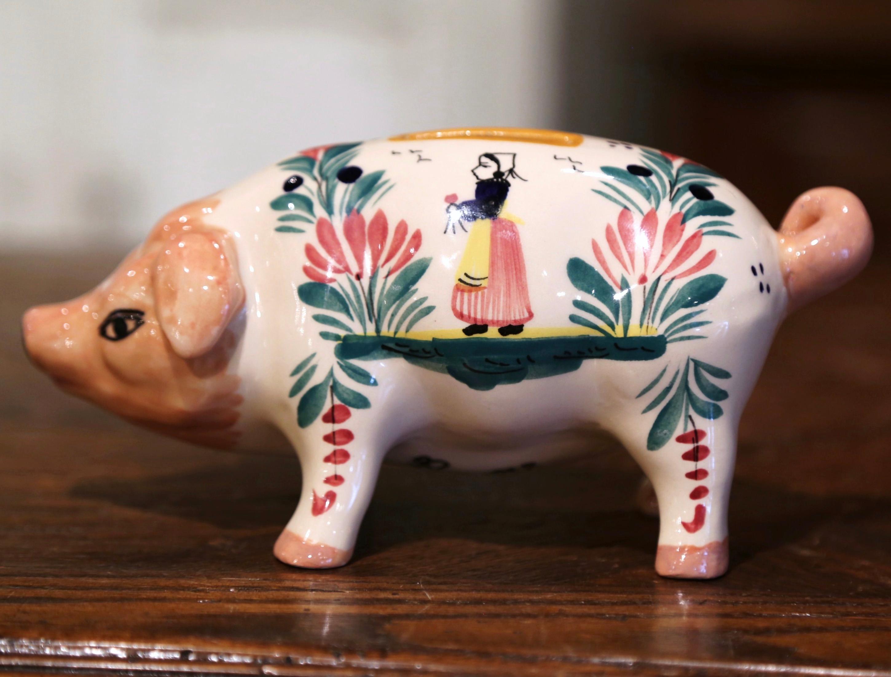 Complete your faience collection with this colorful antique piggy bank from Brittany. Crafted in Quimper, France, circa 1890, the ceramic piece depicts a standing and sniffing pig sculpture with open slot on the top. The coin keeper is decorated