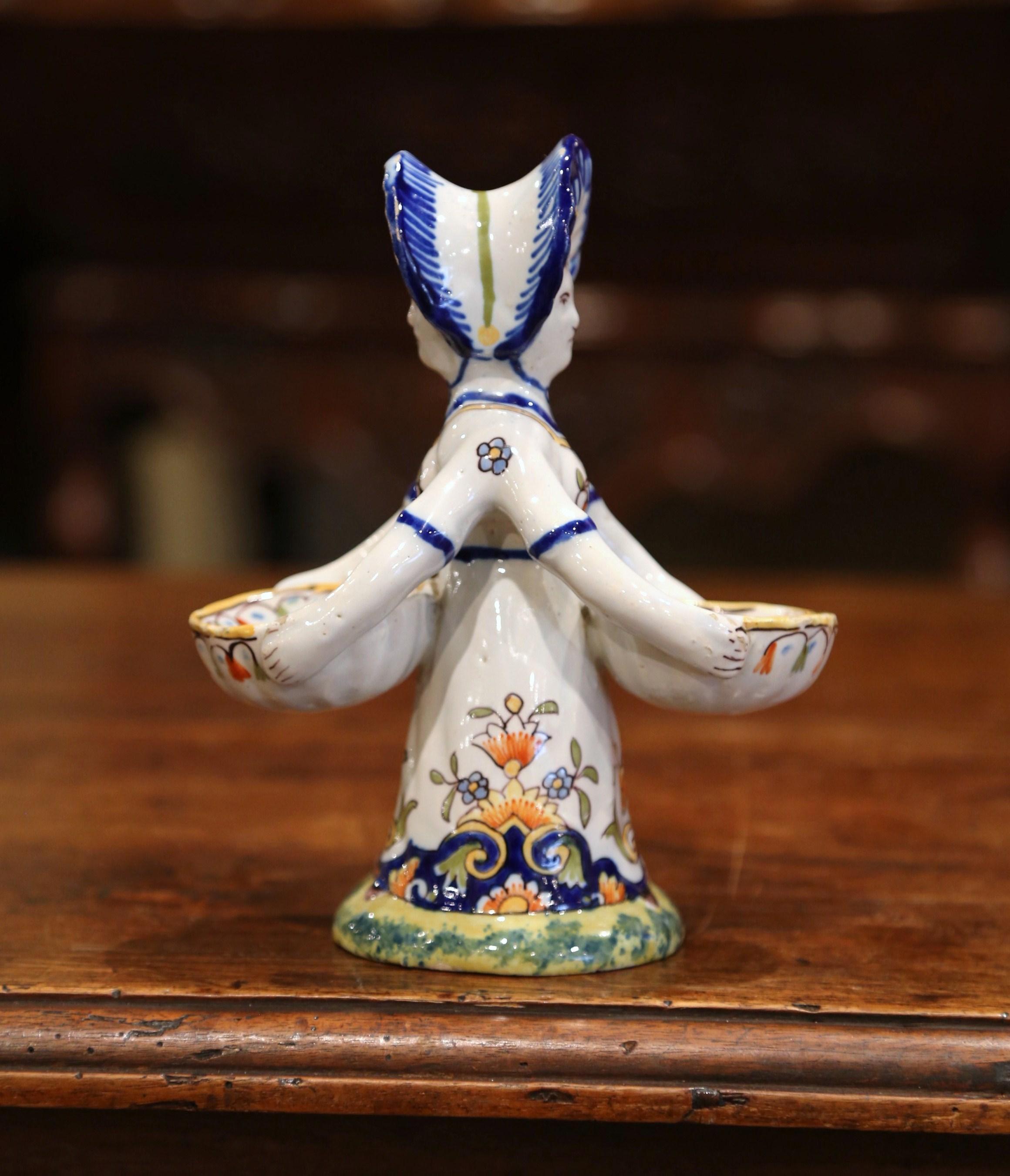 Decorate your dining room table with this colorful antique salt and pepper shaker. Crafted in Brittany, France, circa 1890, the ceramic piece features a Breton lady sculpture holding two small bowls to be used as spices recipients. The piece is in