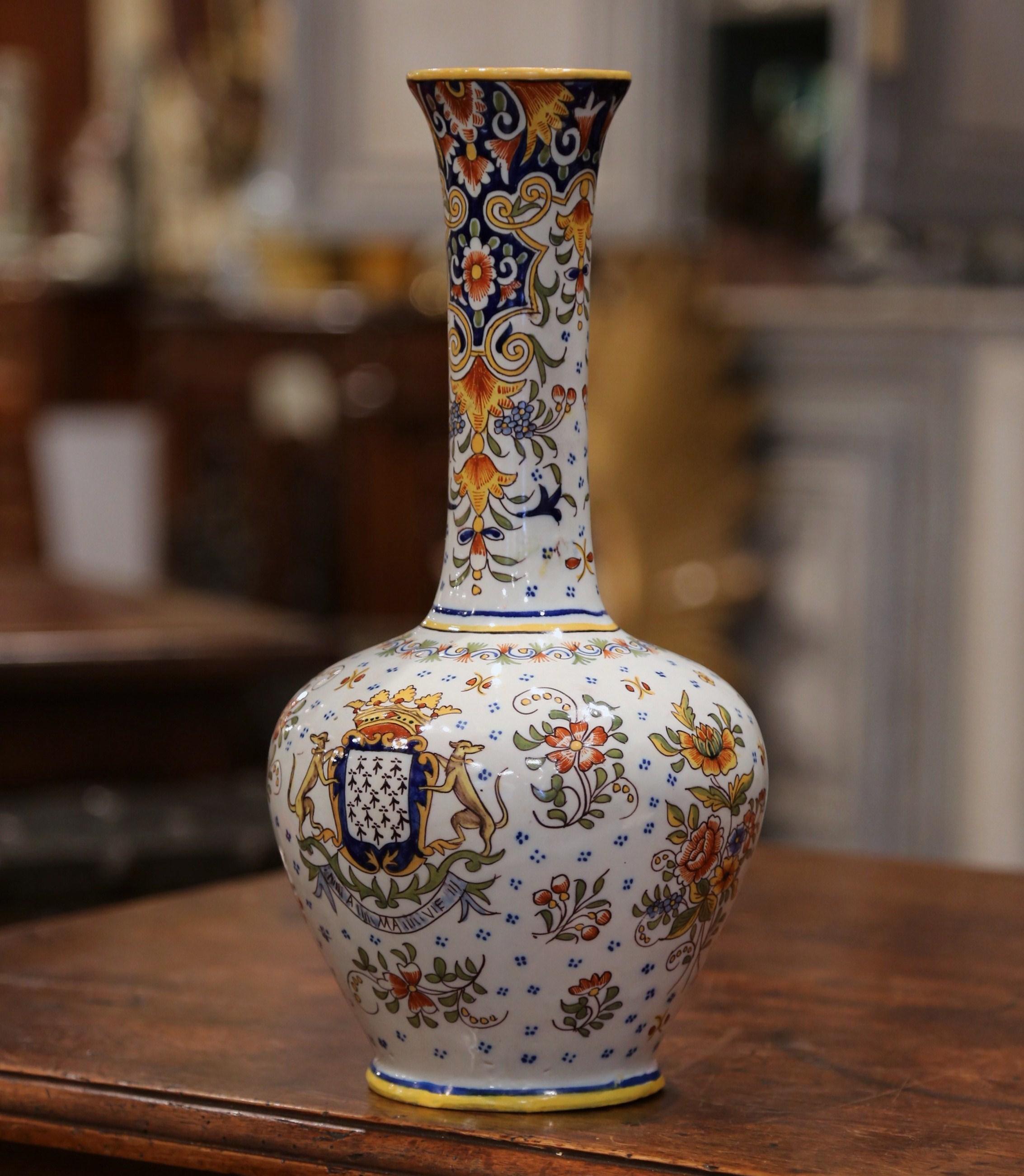 This elegant, colorful, ceramic vase was crafted in Brittany, France, circa 1880. The round, faience vase has a long neck and features decorations that include flowers and leaves. The traditional porcelain vase is hand painted in a Classic blue,