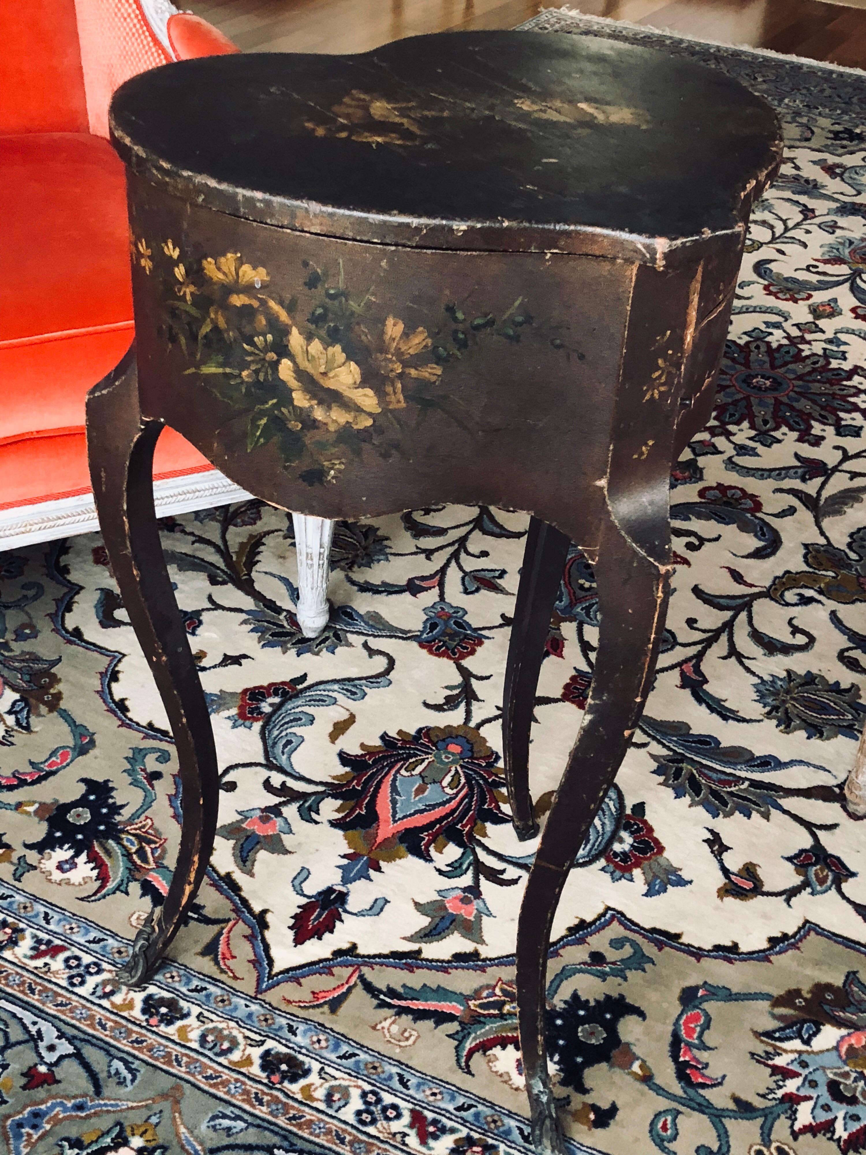 A rare 19th century French heart shape side table in Louis XV style. This piece has fabulous paintings of flowers and cherubs on the top and on both sides and stands over three elegantly curved legs wearing sabot in bronze. it opens from the top and