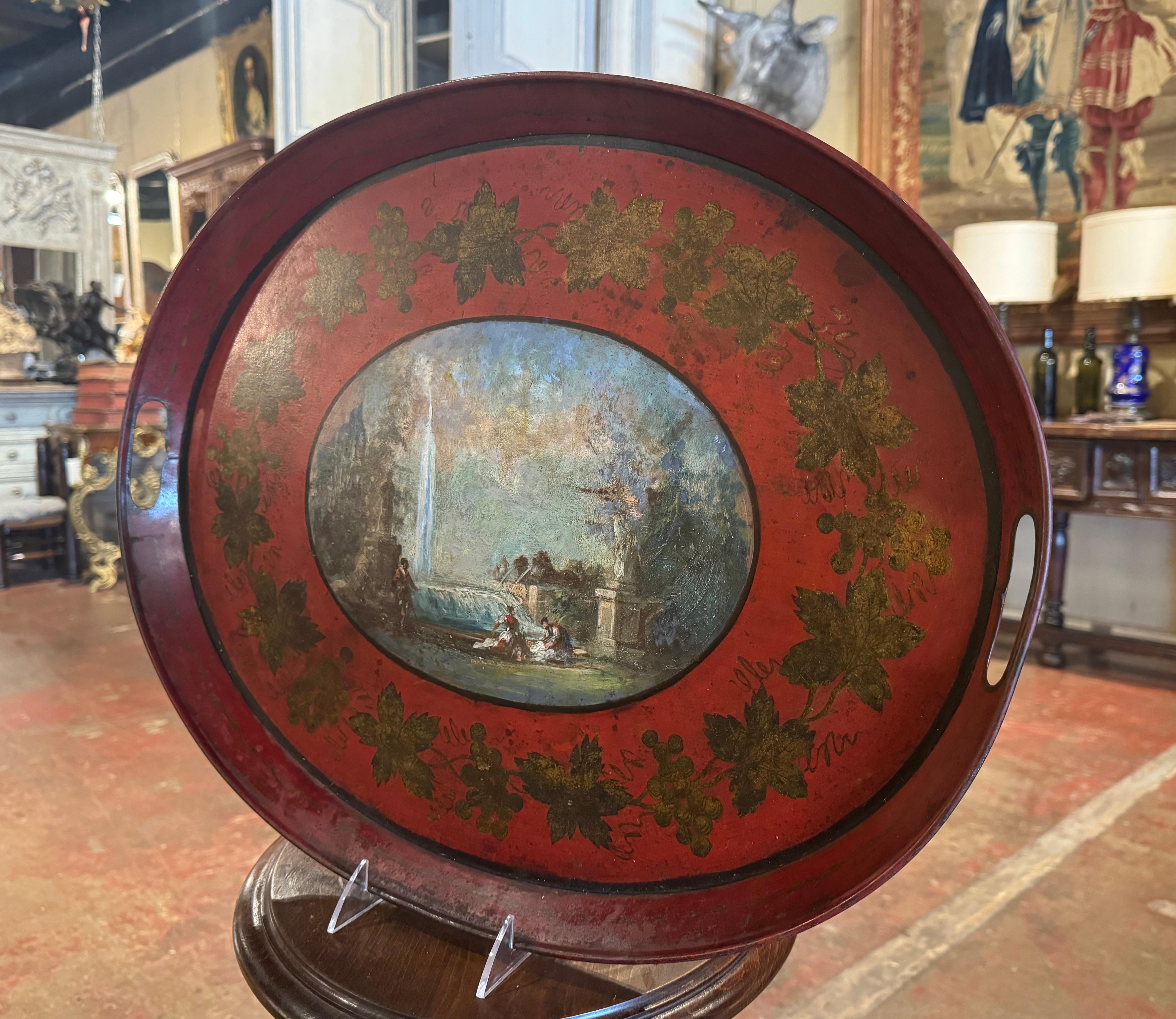 Décorez une table basse avec cet élégant et magnifique plateau ancien. Fabriqué en France vers 1870 et de forme ovale, ce plateau coloré, doté de poignées latérales, présente un médaillon central peint à la main représentant une scène d'extérieur