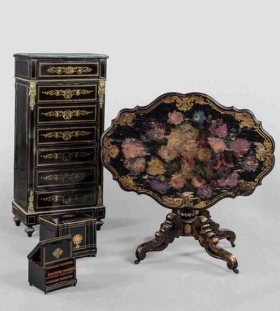 Important French wooden blackened pedestal table. The rocking tray of animated form, receiving in its middle an important decoration of flowers painted and underlined by gilded nets. The table poses on a baluster base and four feet on wheels.