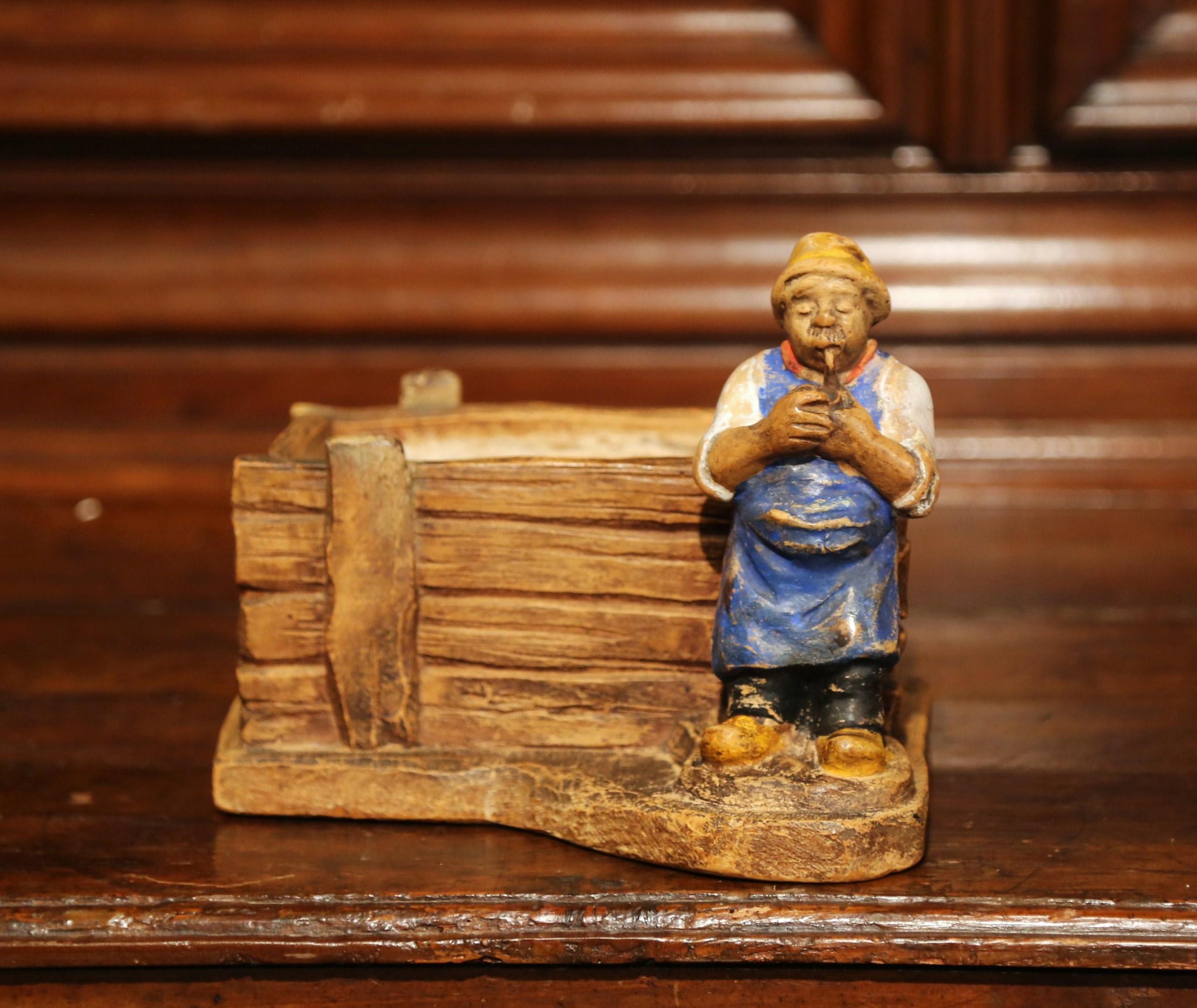 Decorate your kitchen or den with this antique terracotta planter, crafted in France, circa 1880, the earthenware pot features an old man sculpture in high relief smoking his pipe, and a rectangular planter behind him. The jardinière is in excellent