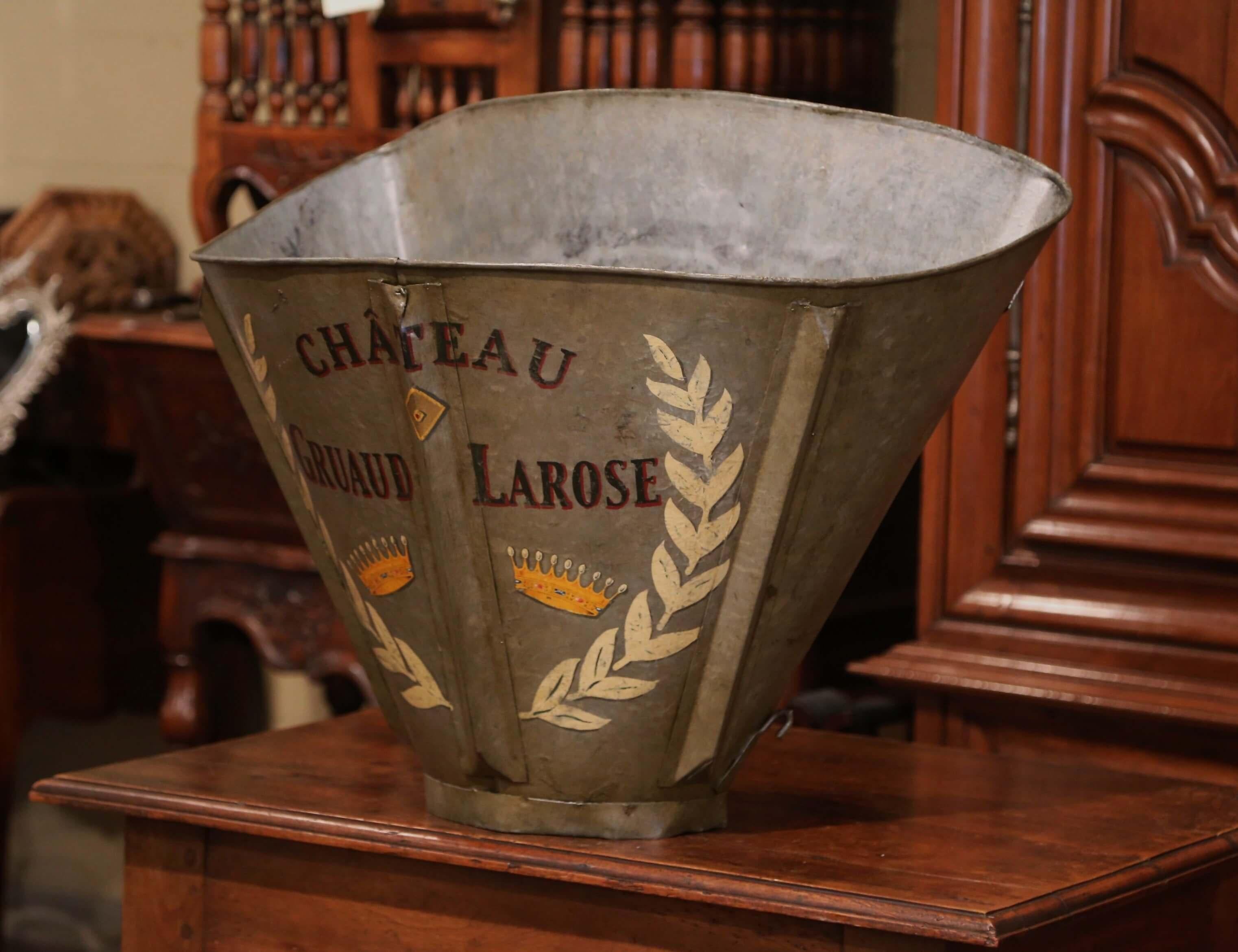 Decorate a wine cellar with this antique, metal grape harvest basket. Created in Southwest, France circa 1870, the unique basket has its original leather back straps and is hand-painted with colorful leaf and crown decor, including 