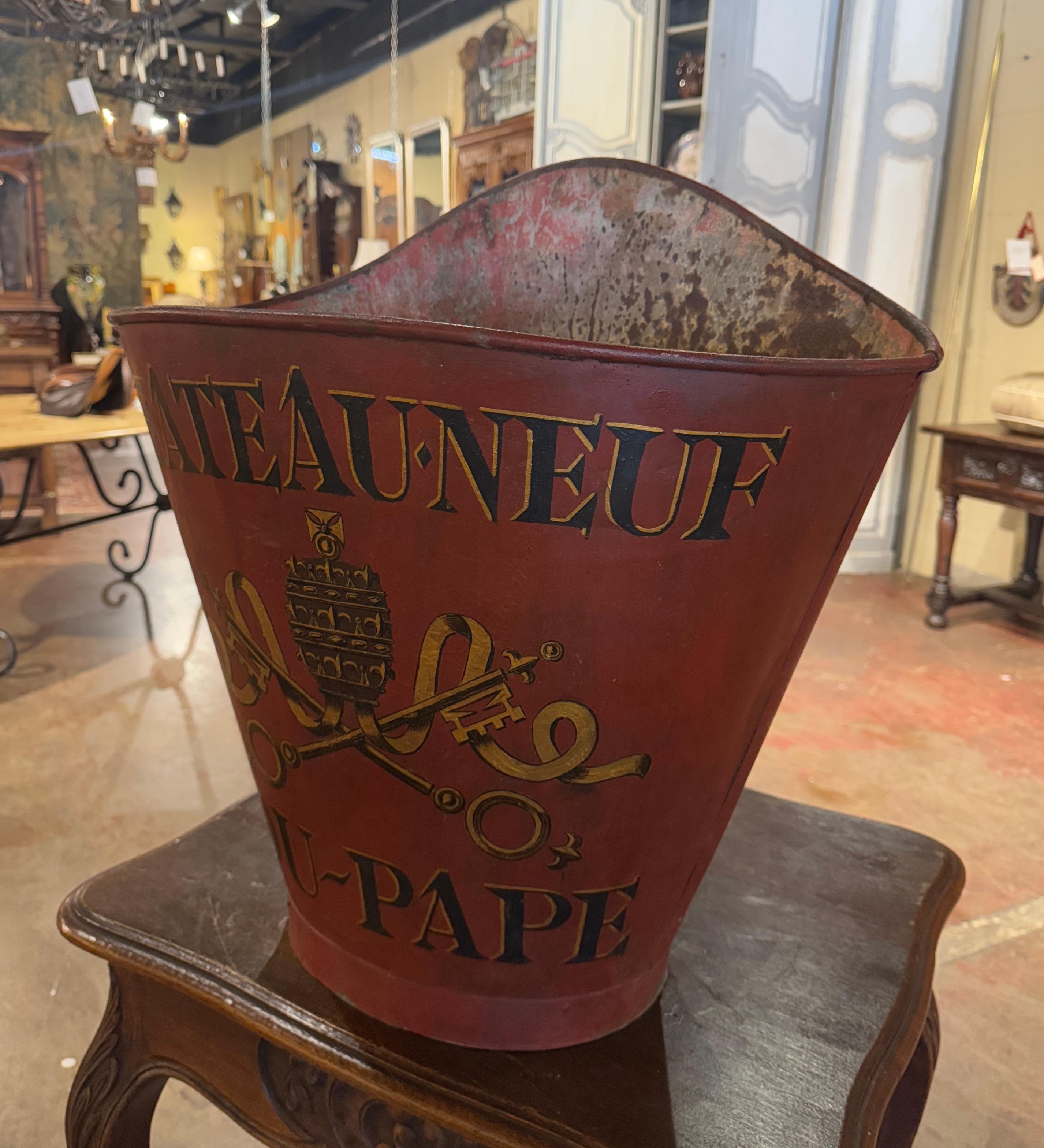 Questo grande e antico cesto per la raccolta dell'uva in metallo è stato creato nella Vallee du Rhone, in Francia, intorno al 1870. Il cesto per vendemmia in metallo galvanizzato è dipinto a mano con scritte colorate a stencil, tra cui il logo