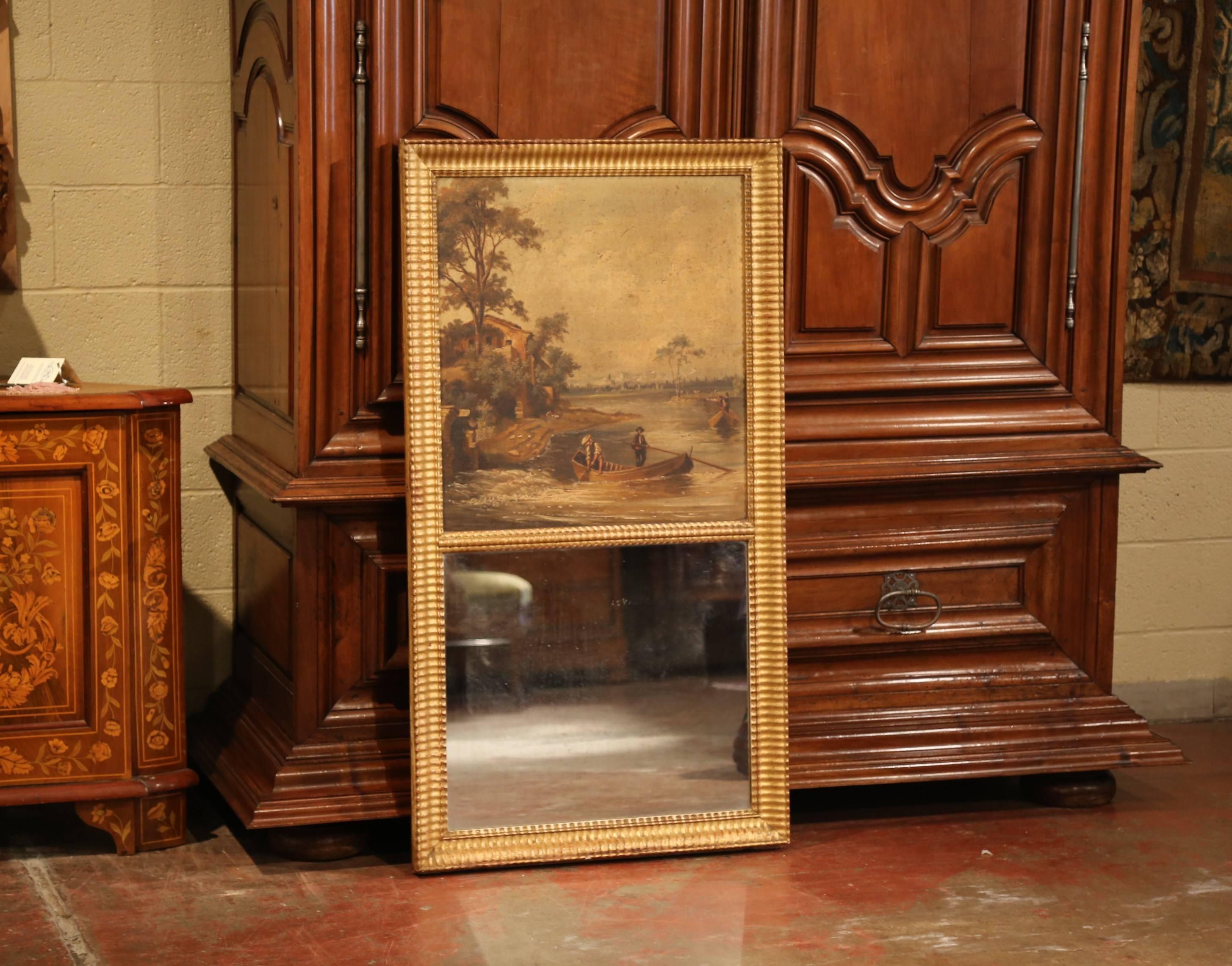Elegant antique trumeau from France crafted circa 1850, the wall hanging mirror features a hand painted pastoral scene on canvas with fishermen and farmhouse in the background. The painting is set in the original carved giltwood frame embellished by