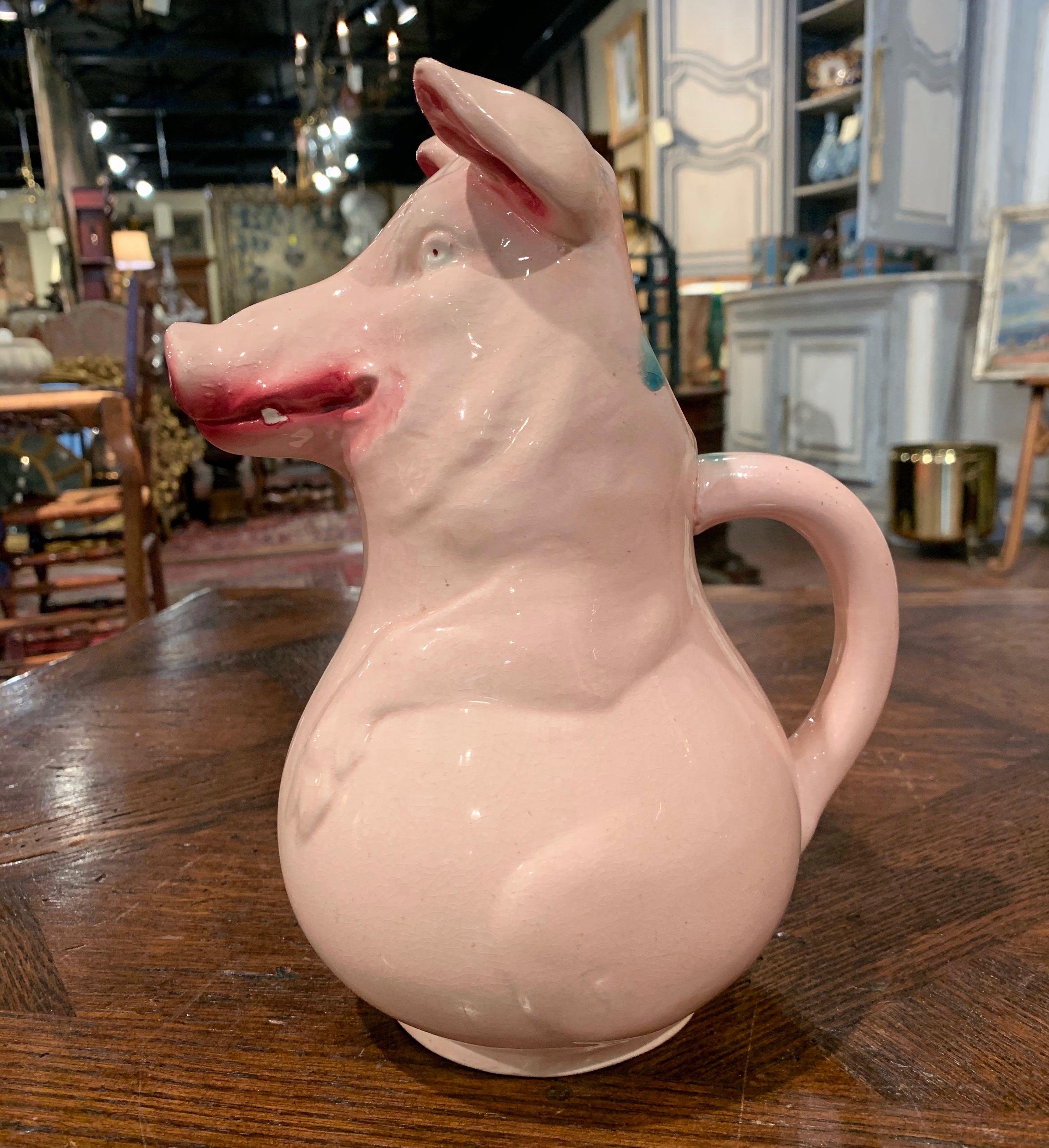 Decorate a shelf or a kitchen counter with this elegant antique barbotine pitcher. Created in Sarreguemines, France circa 1890, the pitcher depicts a smiling pig figure hand painted in a cream palette with pink nose and ears. The water jug is in