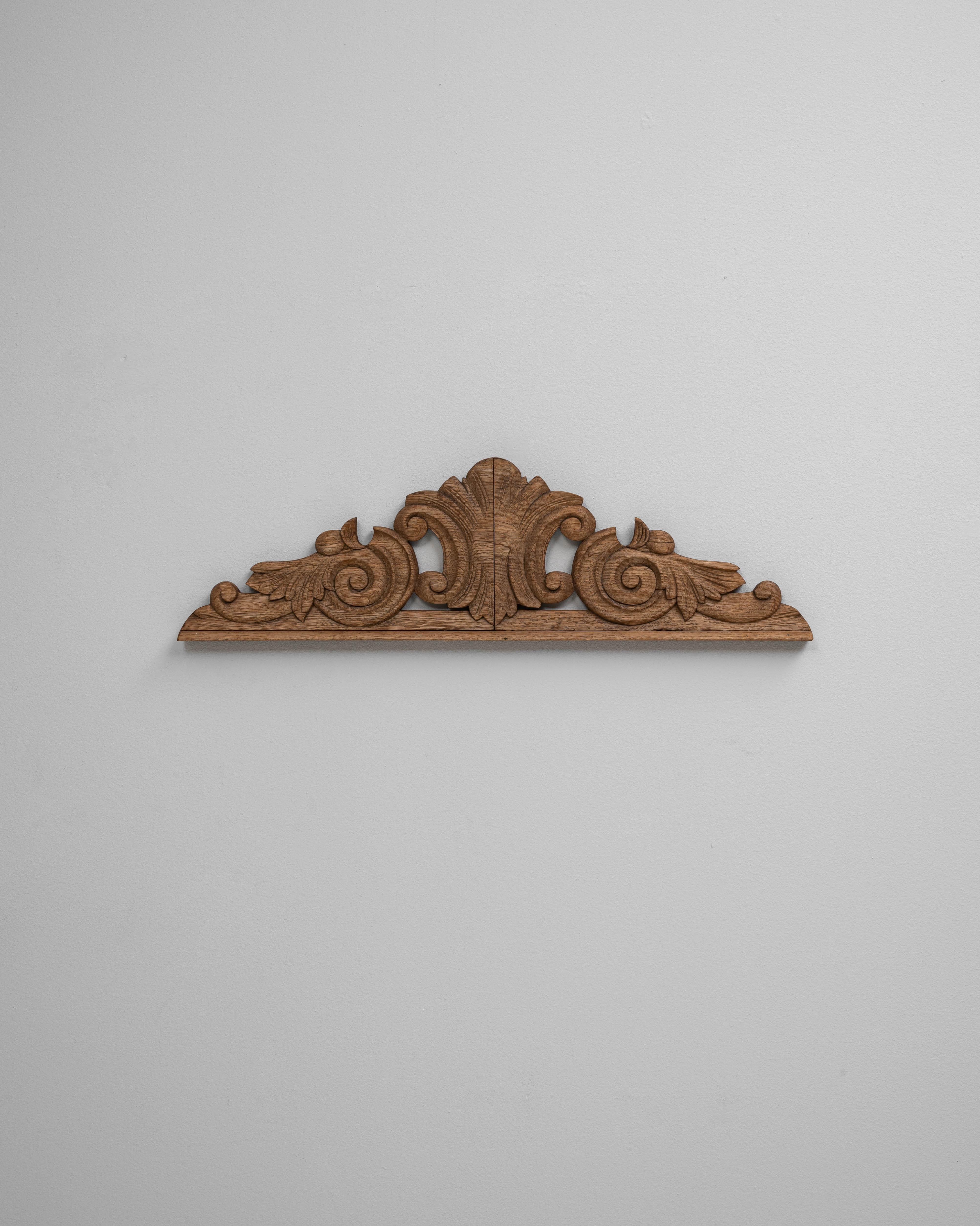Ce fragment d'ornement en bois français du XIXe siècle, fabriqué à la main, présente un élégant design d'inspiration classique, avec des feuilles d'acanthe, des volutes et des rinceaux symétriques finement sculptés. Provenant probablement d'un