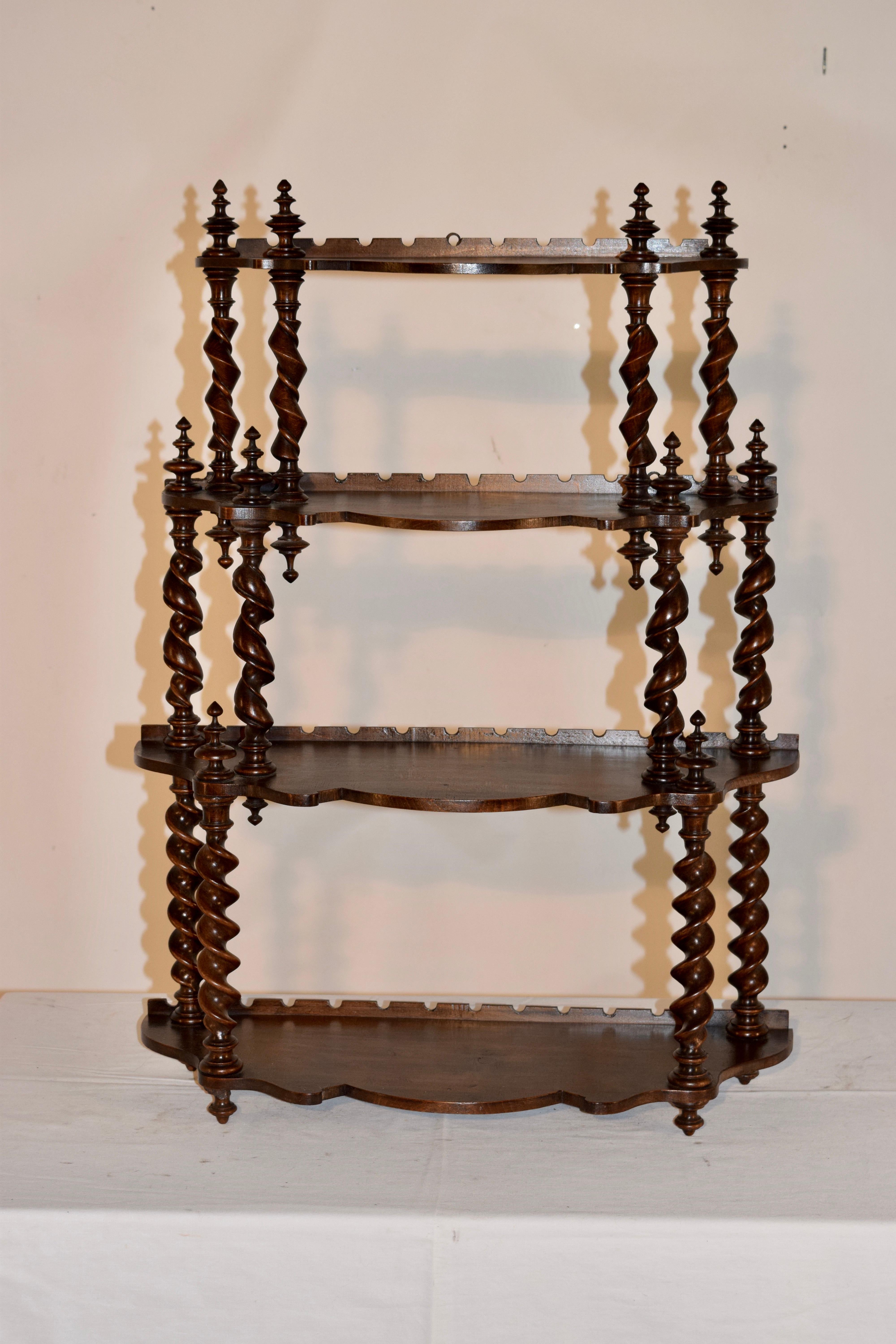 19th century French hanging shelf made from mahogany with three distinctive types of hand-turned twist shelf supports. The shelves are scalloped and have a wonderful shape to them. Interesting shelf for any collection.