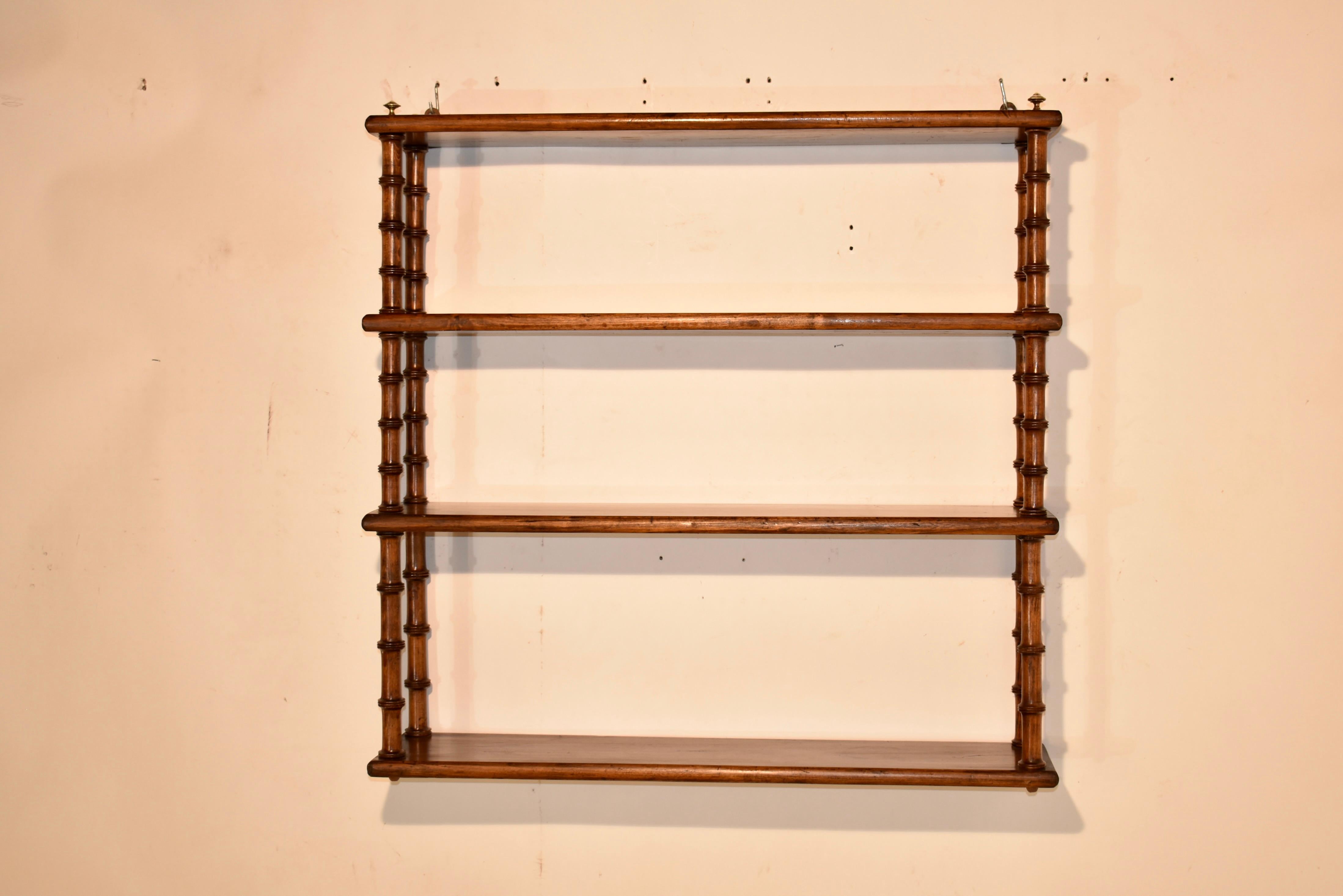 19th century hanging wall shelf from France.  The shelf is made from cherry and rosewood.  There are four shelves, all made from rosewood, joined by hand turned cherry shelf supports.  This is a lovely small shelf, which would be great in a