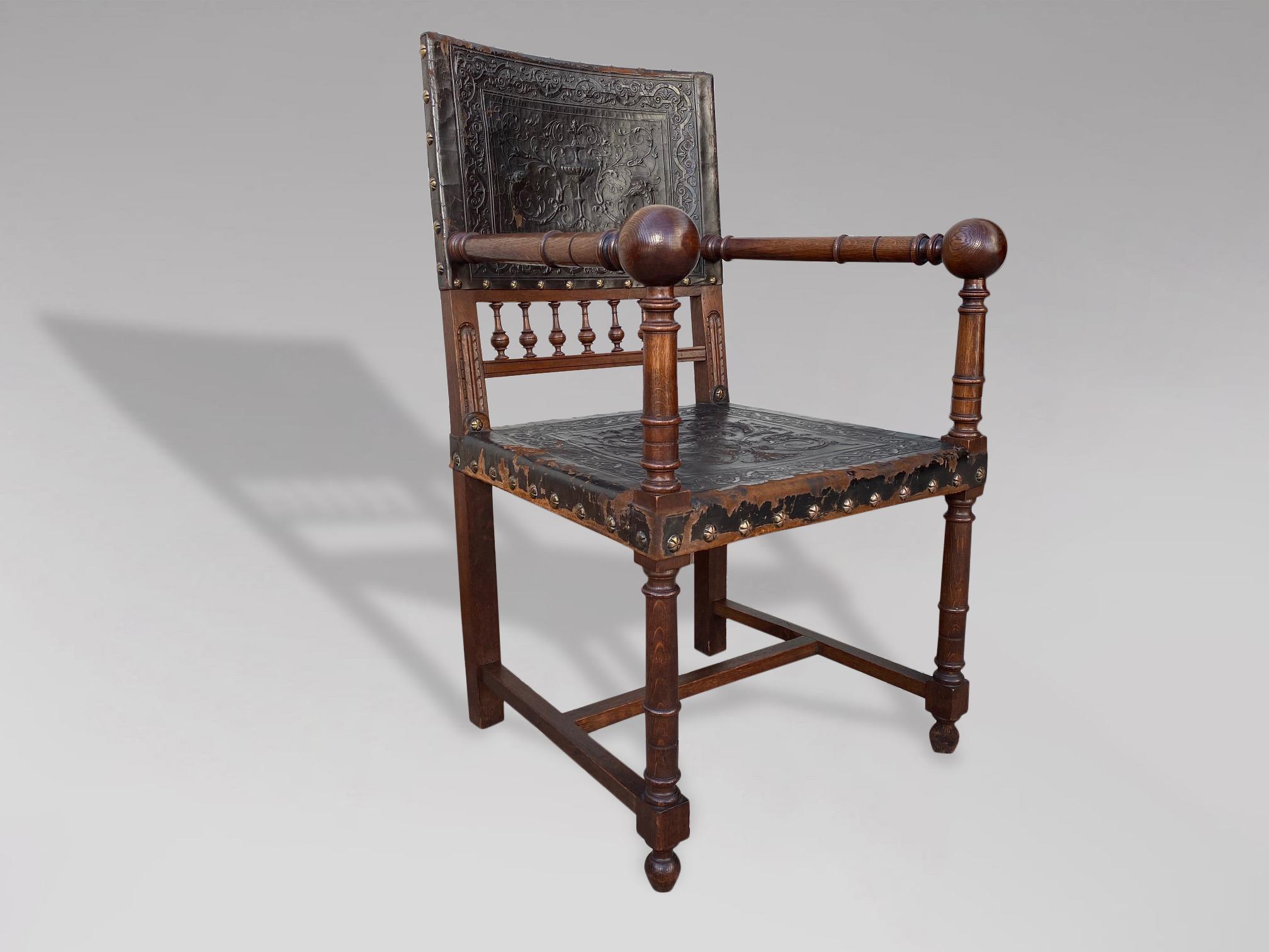 Très beau fauteuil ou fauteuil à bras en cuir et en chêne de la Renaissance française Henri II du 19e siècle, avec des cadres en chêne magnifiquement sculptés à la main et des clous en laiton façonnés. Les pieds droits tournés sont reliés par un