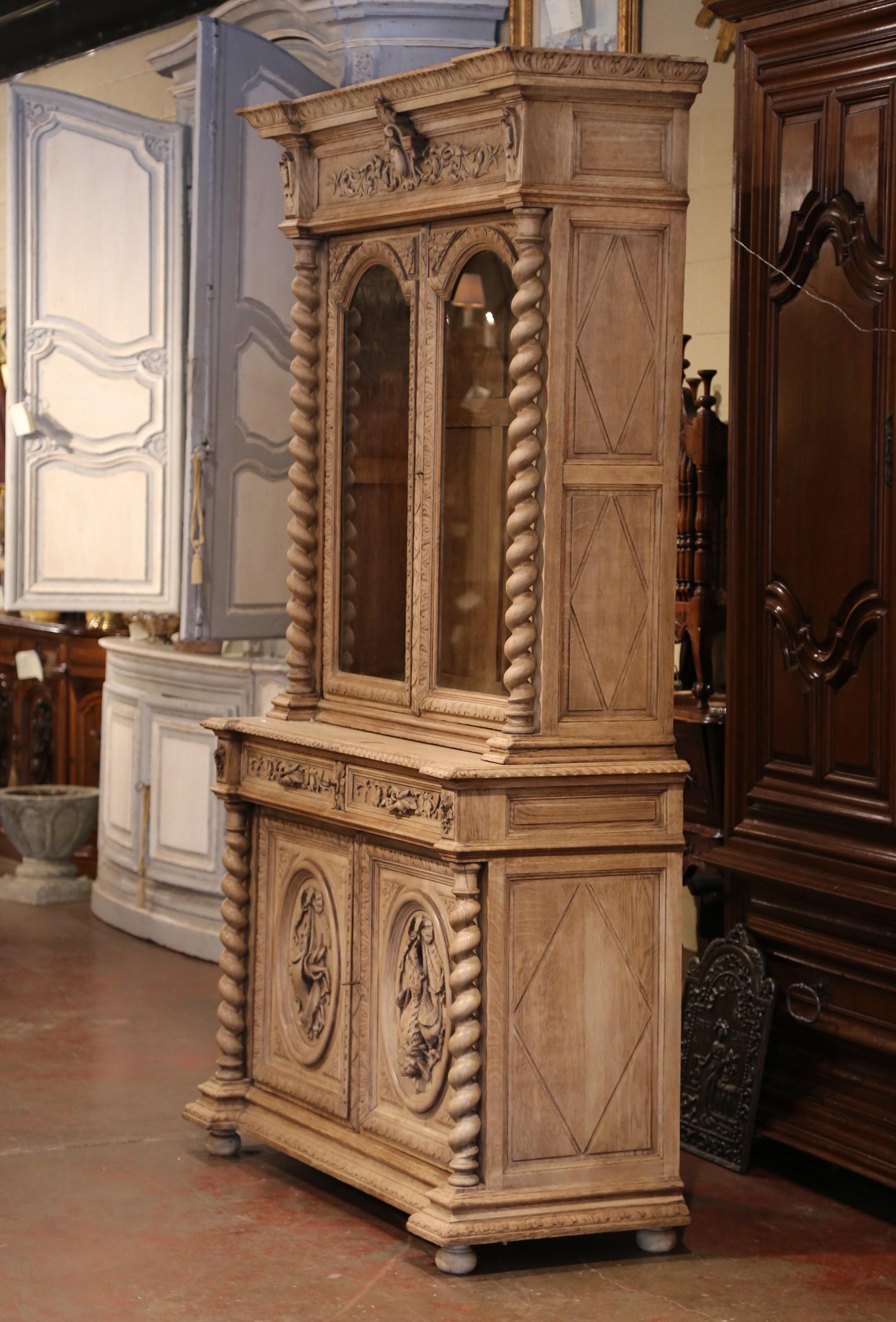 Display your rifle or shotgun collection in this beautifully carved, antique gun cabinet. Created in France, circa 1880, the two-piece buffet with barley twist columns sits on four bun feet over a recessed plinth at the base. The top features a