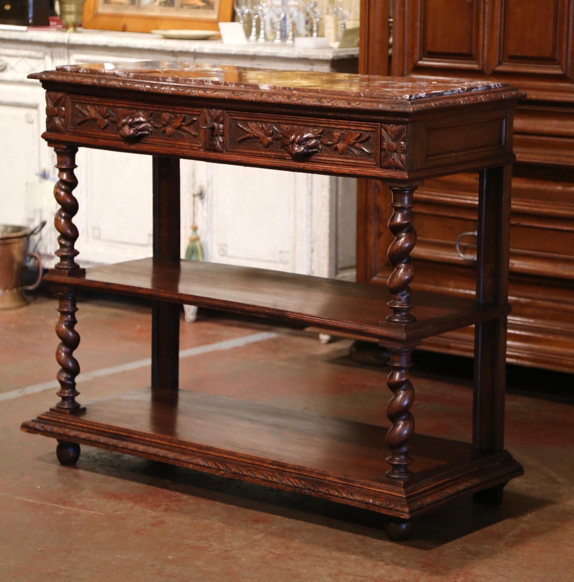 Crafted in France circa 1870, the antique Gothic style console stands on barley twist legs ending with bun feet, over a decorative plinth base. The desserte is dressed with a variegated red marble surface set inside a carved edge rectangular frame,