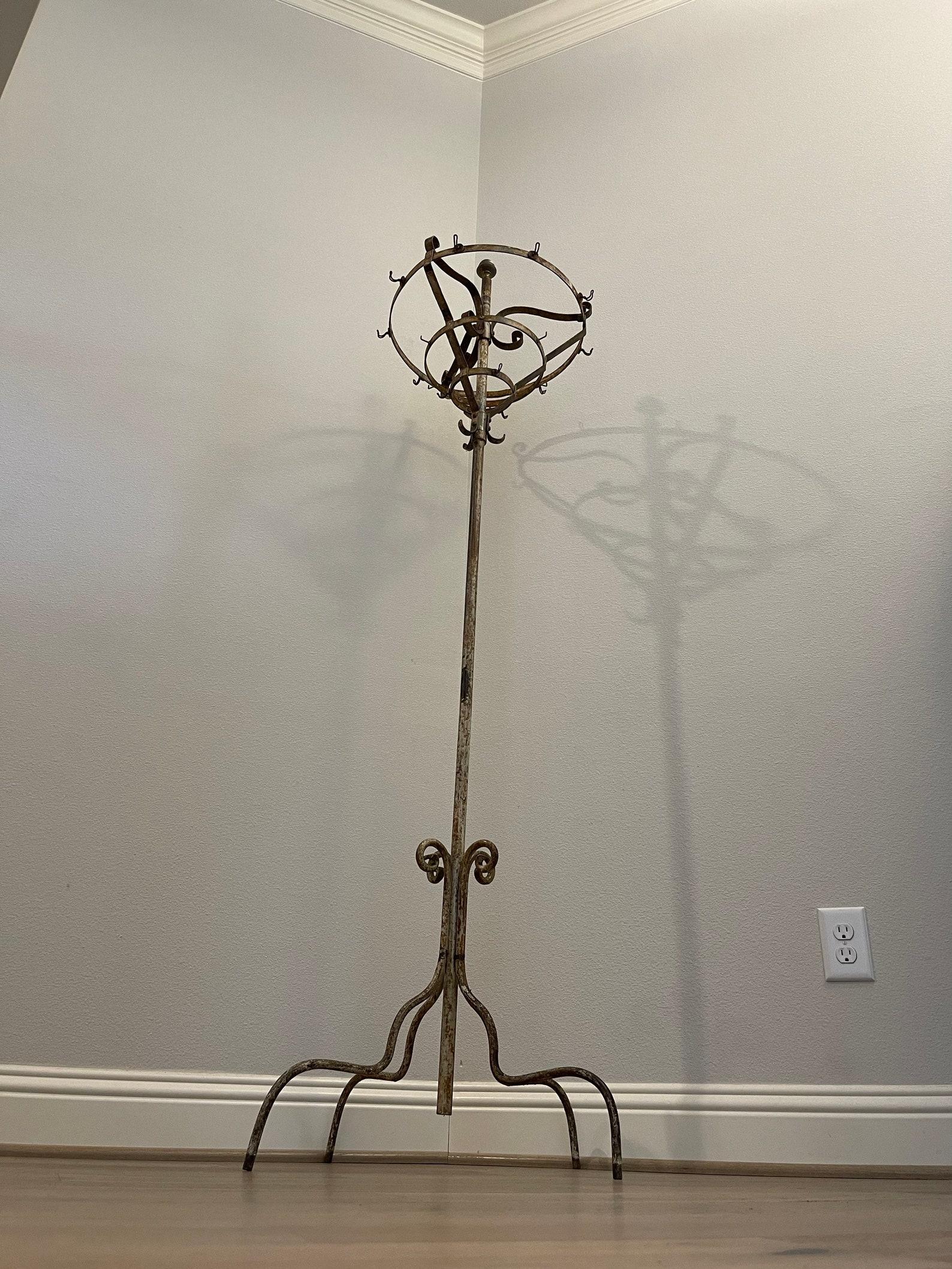 A scarce tall antique French industrial hotel rounder coat rack stand. 

Born in France in the late 19th century, highly desirable and sought after, featuring rustic forged wrought iron construction, strong and sturdy utilitarian design with a touch