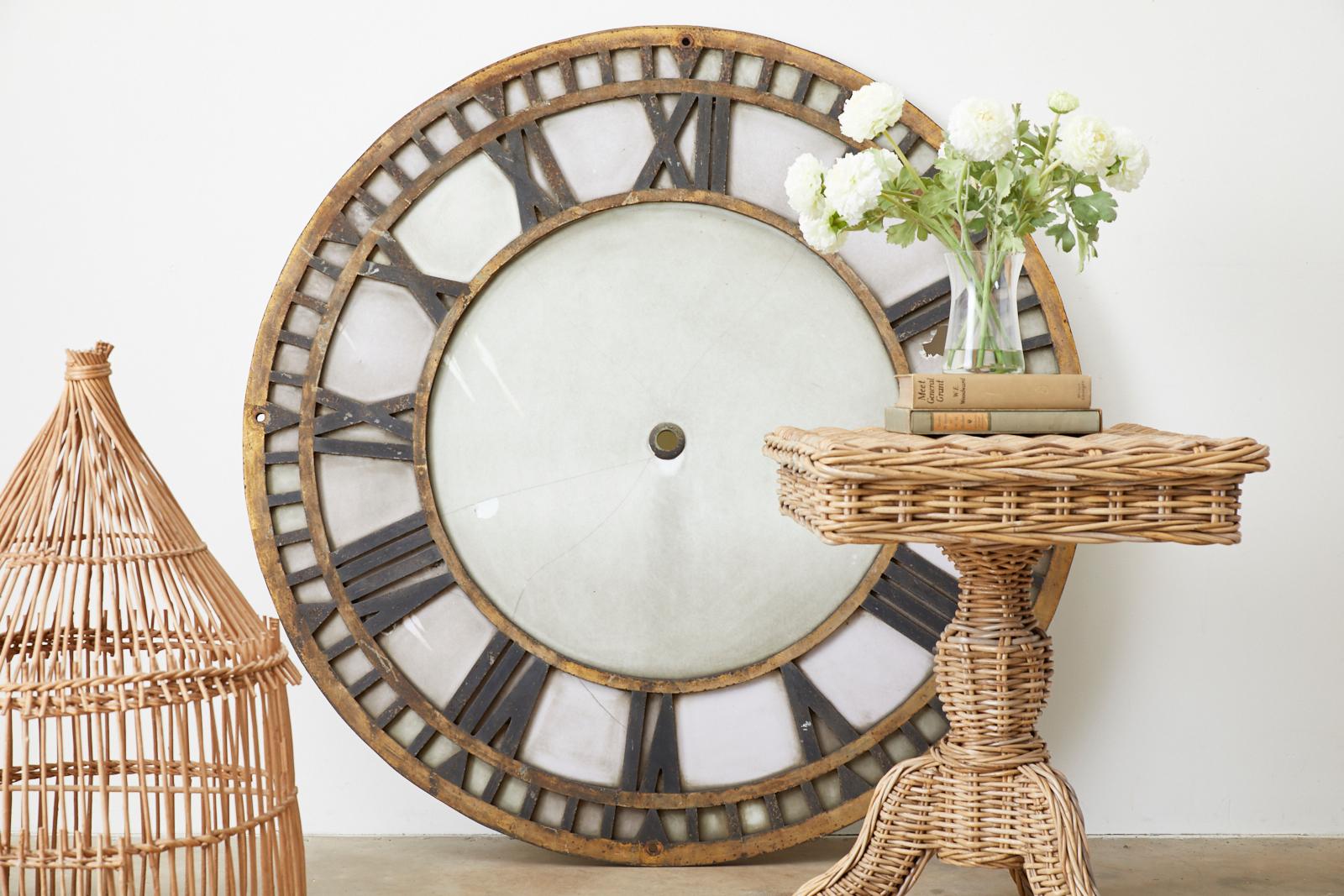 Monumental 19th century French clock face constructed from a 1.25 inch thick iron frame. The large face features Roman numerals and a parcel gilt finish with a beautifully distressed patina. The frame is inlaid with old milk glass. Originally from