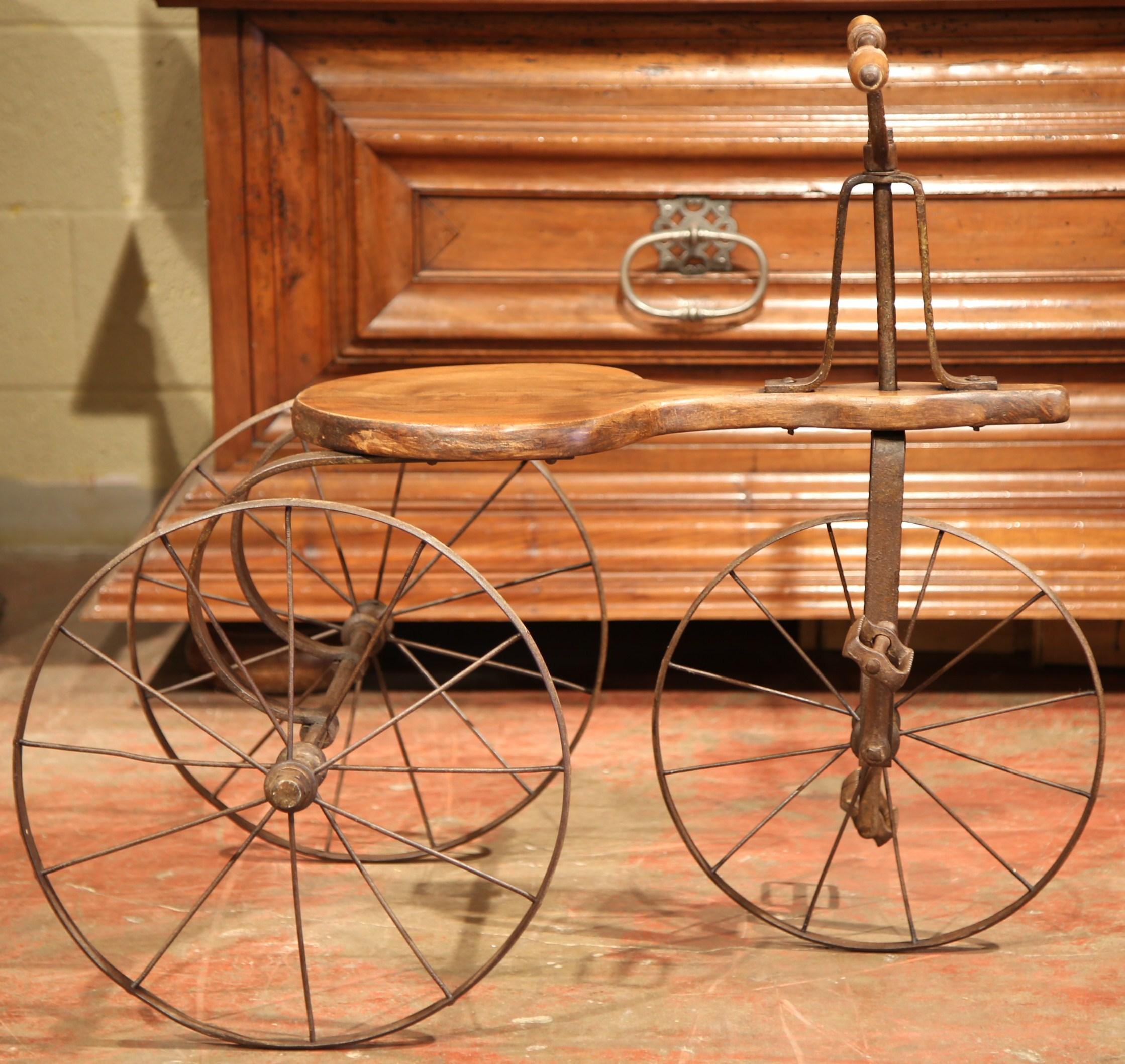 This beautiful, antique tricycle was created in France, circa 1880. The child's bicycle has a walnut seat and walnut handles with forged wheels and thin frame. The authentic children's toy is in excellent working condition with original patinated