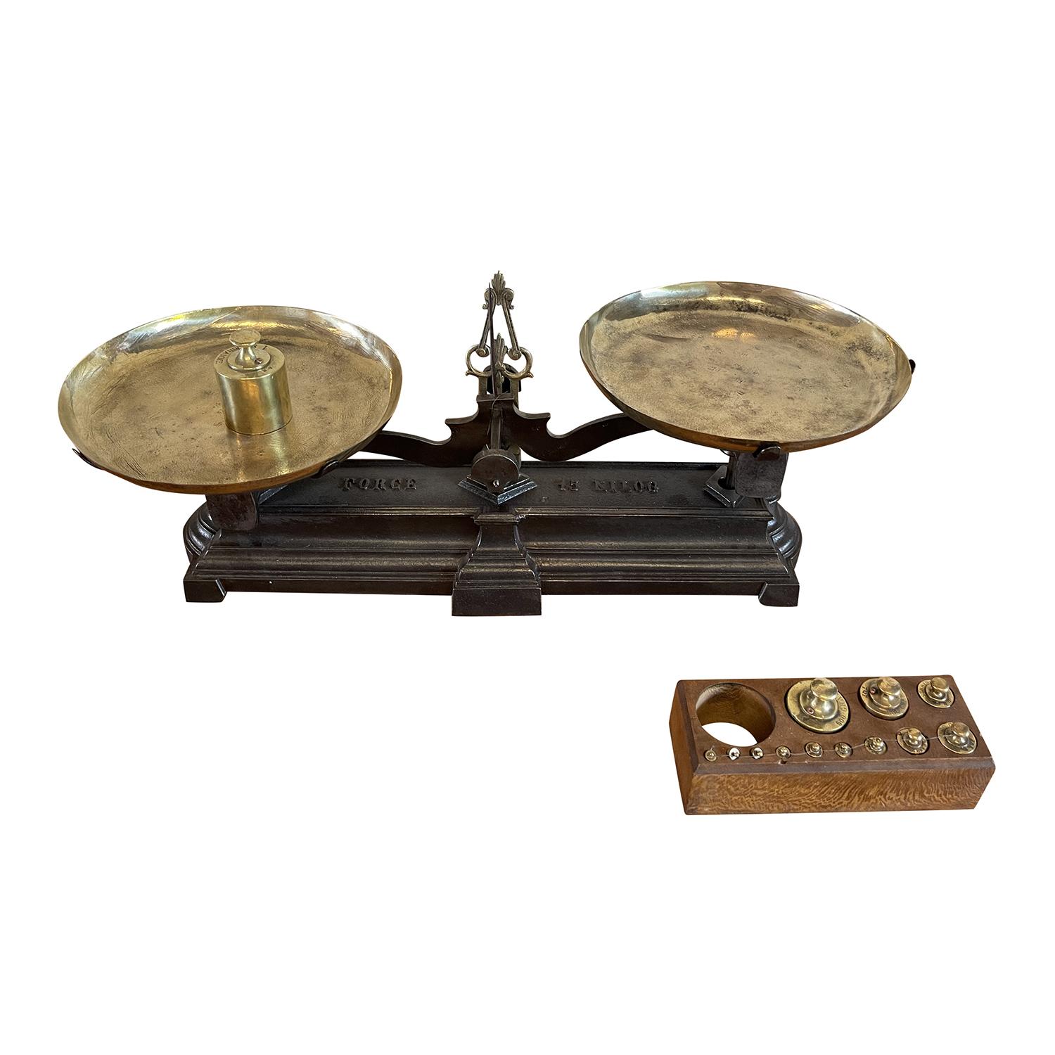 An antique French intricate brass balance with different weights in solid brass, in good condition. The iron scale is topped with the original polished brass plates. The scale reads “FORCE 15 KILOG”. Wear consistent with age and use. Circa 19th