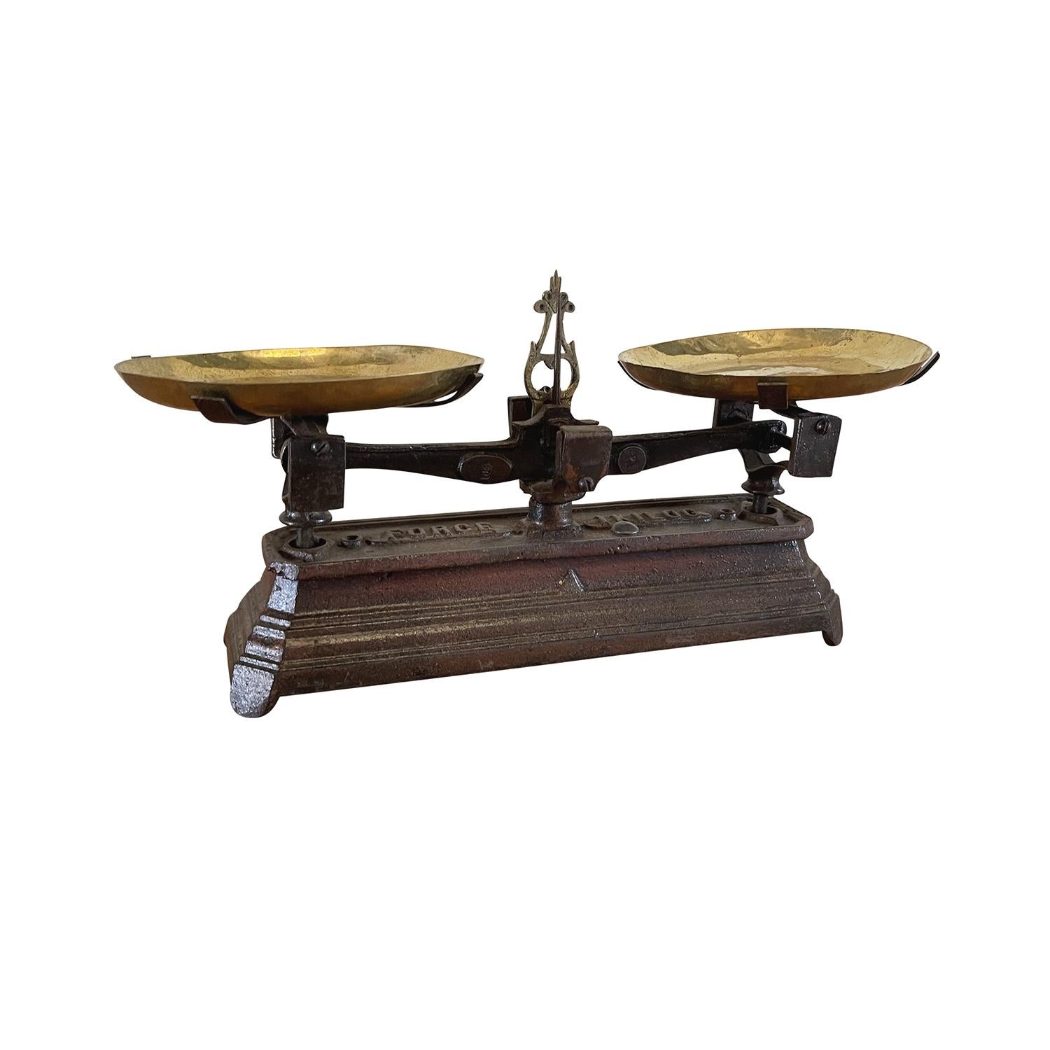 A small, antique French intricate brass balance with different weights in solid brass, in good condition. The iron scale is topped with the original polished brass plates. The scale reads “FORCE 1 KILOG”. Minor fading, scratches due to age. Wear