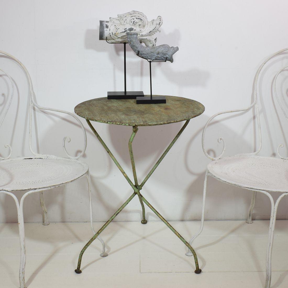 Great iron bistro table with a beautiful traces of its old green paint. Unique folding system
France, circa 1880-1900 height when folded = 83cm
Weathered.
 