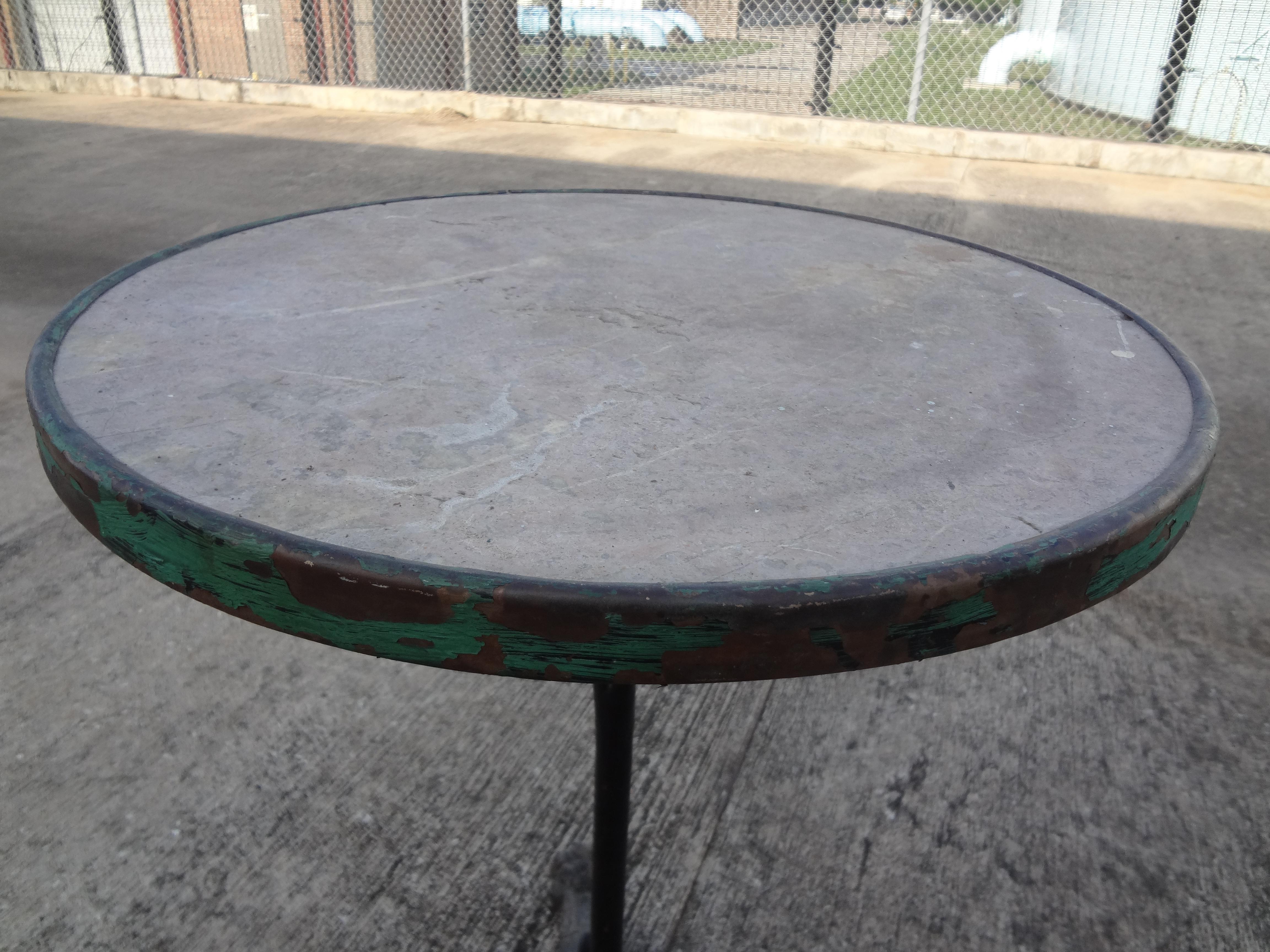 Charming antique French iron tripod bistro or garden table with a stone top. This great little table has a lovely distressed chippy oxidized patina. It would work equally as well indoors as a side table or drinks table or as a garden table.