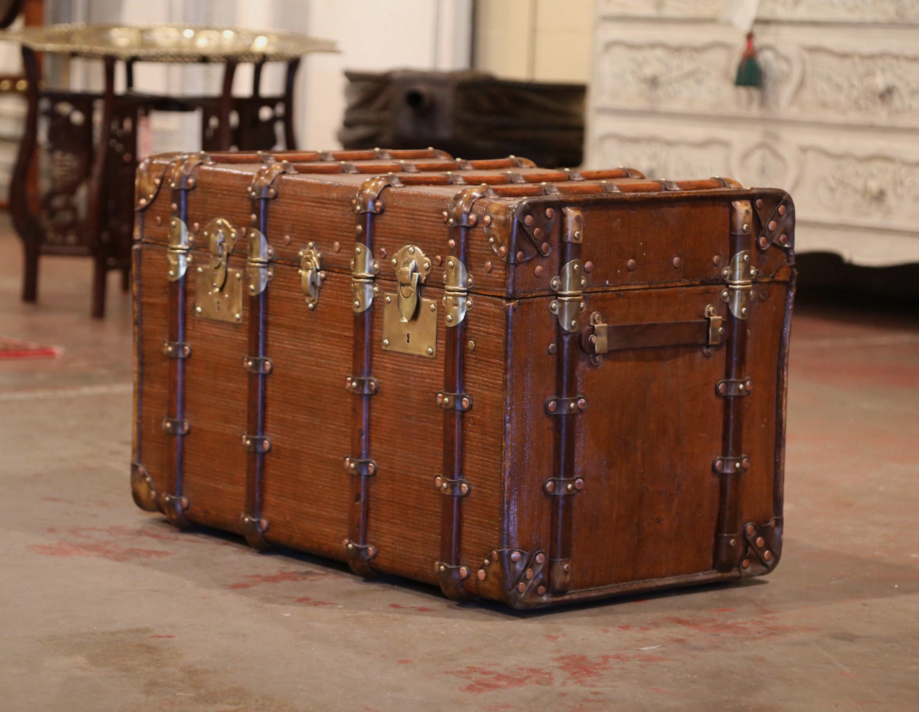 This large Vuitton style trunk would make an elegant coffee or cocktail table! Crafted in Paris circa 1880, the antique luggage is rectangular in shape, and finished on all five sides including the top; it features heavy leather side handles,