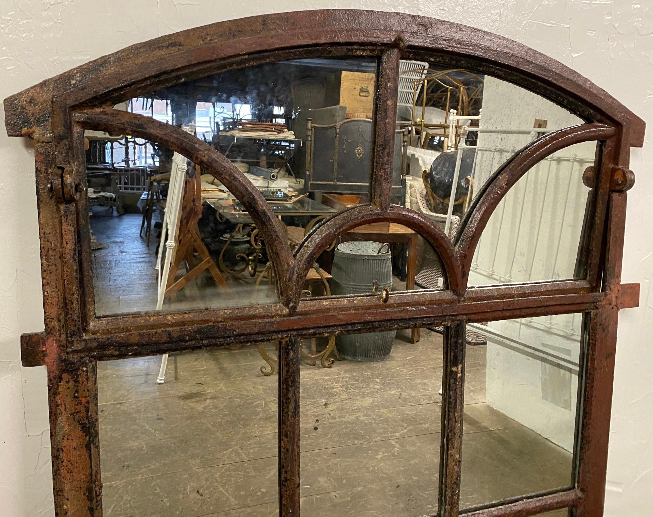 A handsome and elegant antique Neo-classic Tuilleries Orangerie wall mirror with arched top made of hand crafted cast iron antique frame that once was a window from a French chateau with inserted mirrored panels.
Can be used as a wall hanging or in