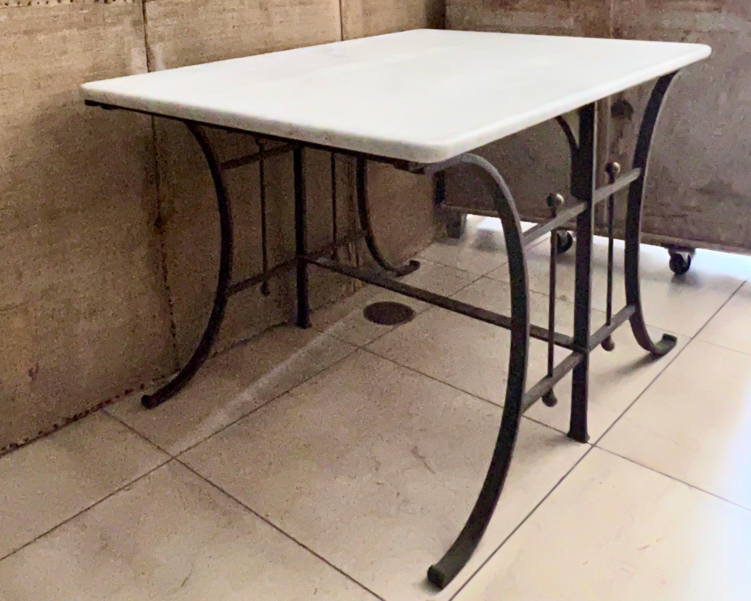 19th century French pastry, console, center table in clean line heavy iron base with recent white thick Carrara marble top with light grey veining.
The tables like these have been used as display table in the French Patisseries or Butcher shops.
 