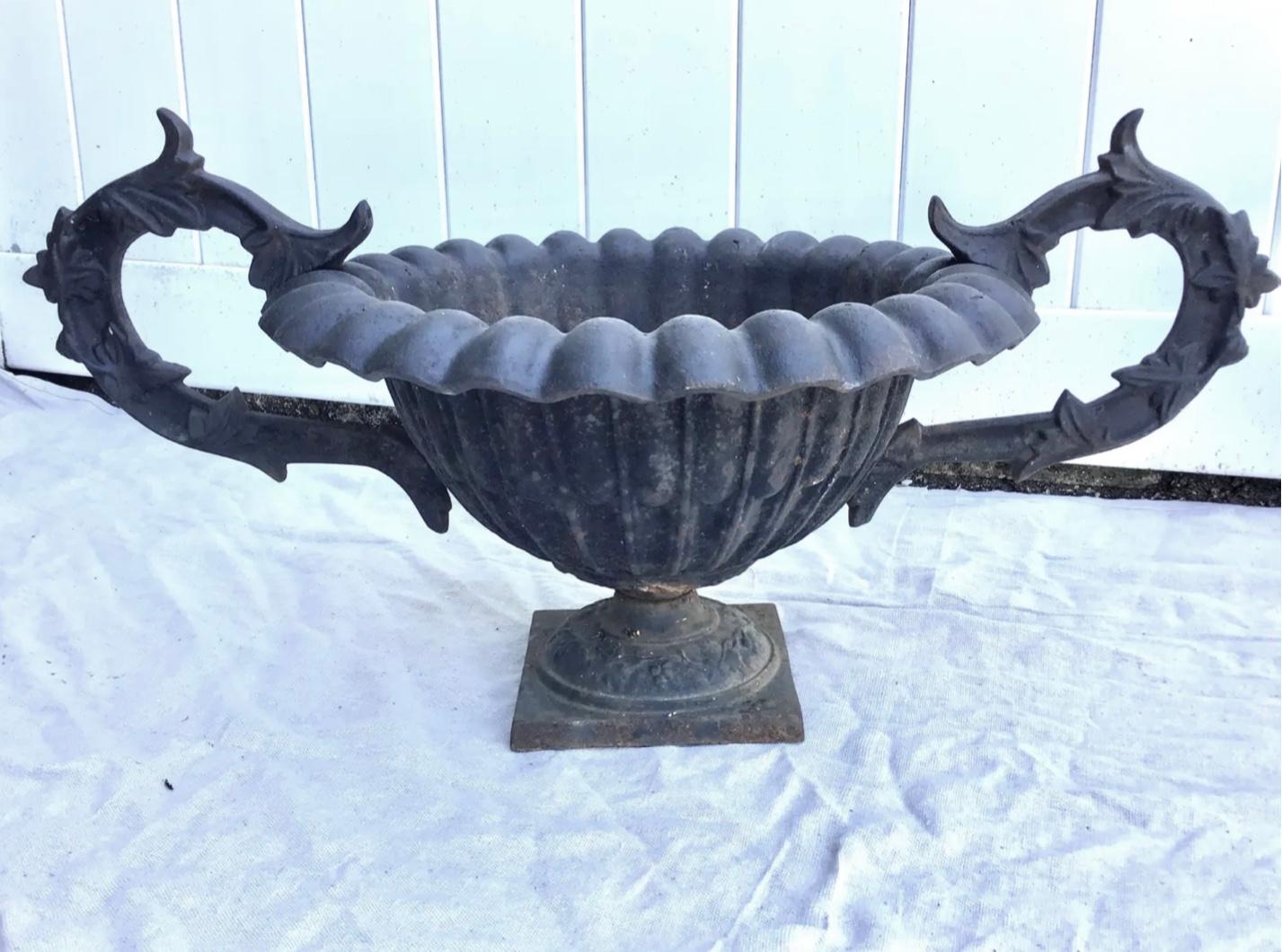 Pair of 19th century French round shaped iron planters with scroll design sides and a floral relief design and scalloped top. Very detailed handles. Wonderful old patina.