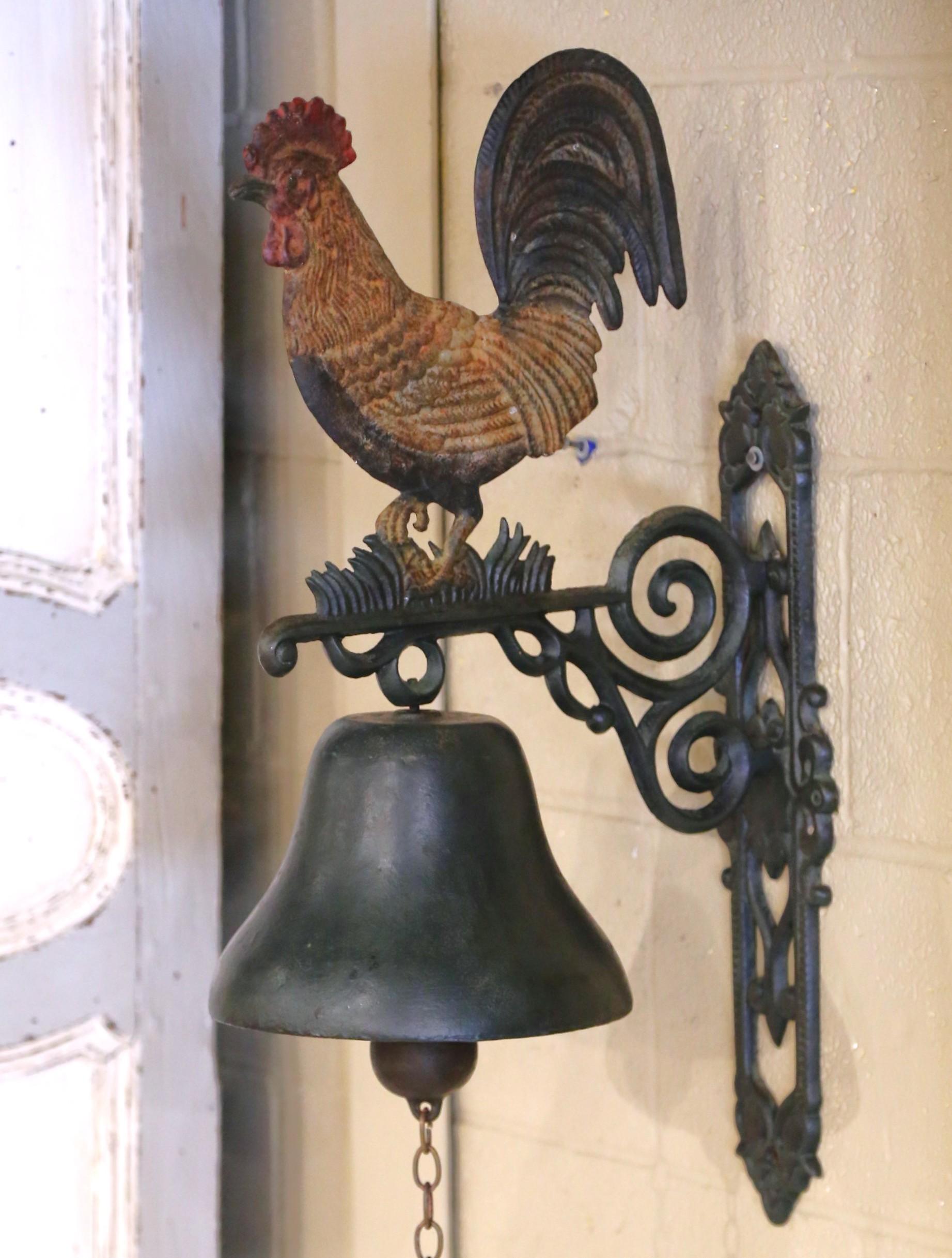 Ajoutez un charme français rustique à votre espace avec cette cloche murale en fer ancien, fabriquée en France vers 1880. Le support décoratif est orné de rinceaux et de détails floraux et supporte une cloche en fonte surmontée d'un épi de faîtage