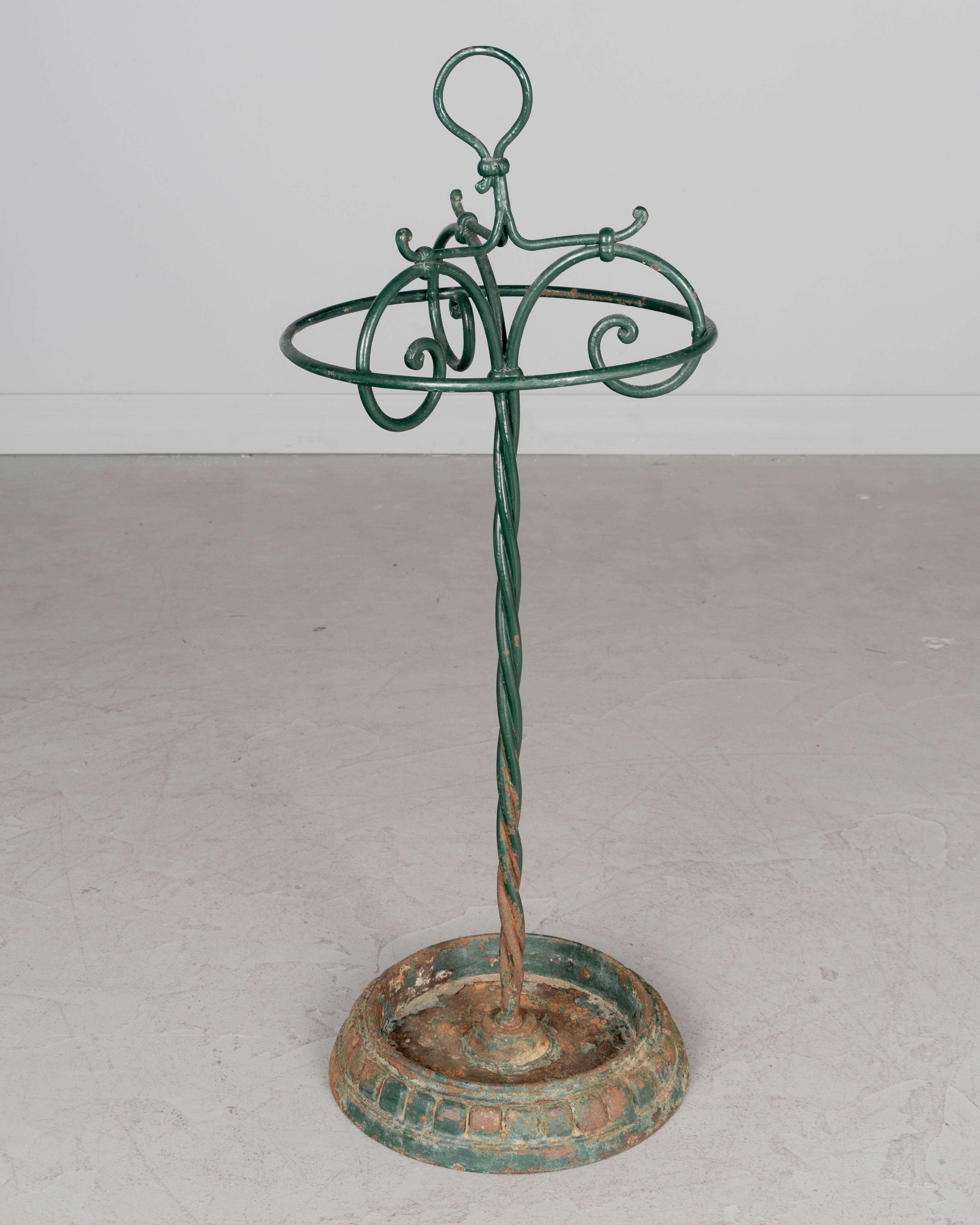 Porte-parapluie français en fonte du XIXe siècle, avec tige en fer forgé torsadé et lourde base en fonte. Finition peinte en vert avec patine rouillée. Légèrement incliné. Vers 1870-1890
Dimensions : 31 