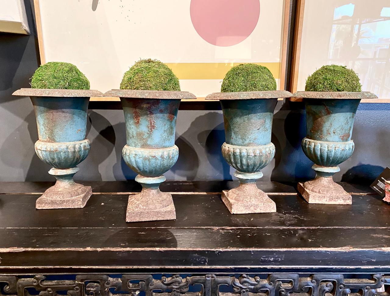 This is a highly decorative grouping of 4 matched French iron urns in a traditional French blue/green painted surface that has acquired a gorgeous deep natural patina over their i50 years of life. To find such a large set of matched urns, with this