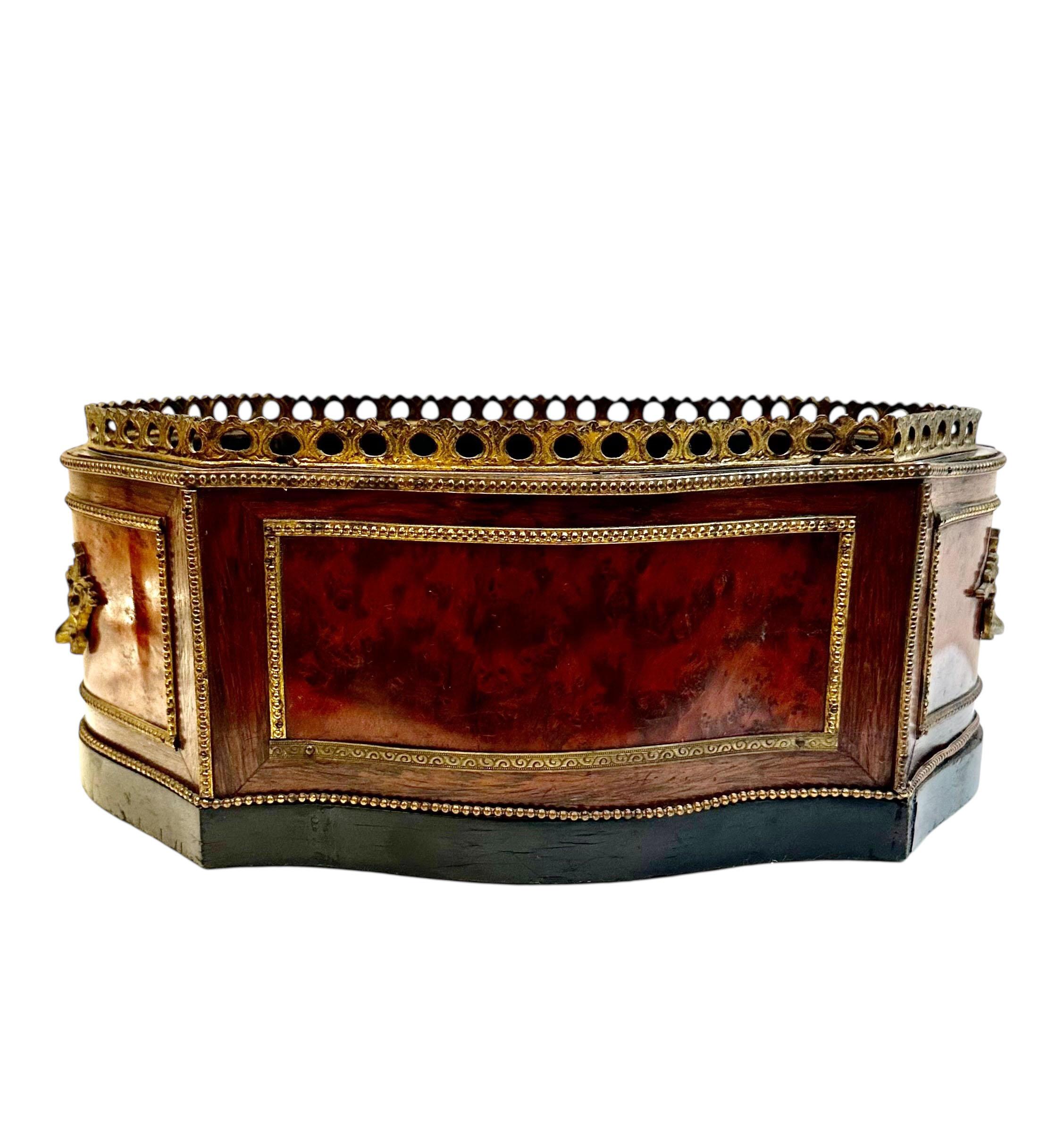 An elegant 19th century French jardinière featuring a finely cast dore bronze gallery and handles, paired with a striking marquetry body inlaid with exotic woods. The warm, contrasting tones create a refined decorative rhythm, highlighting the