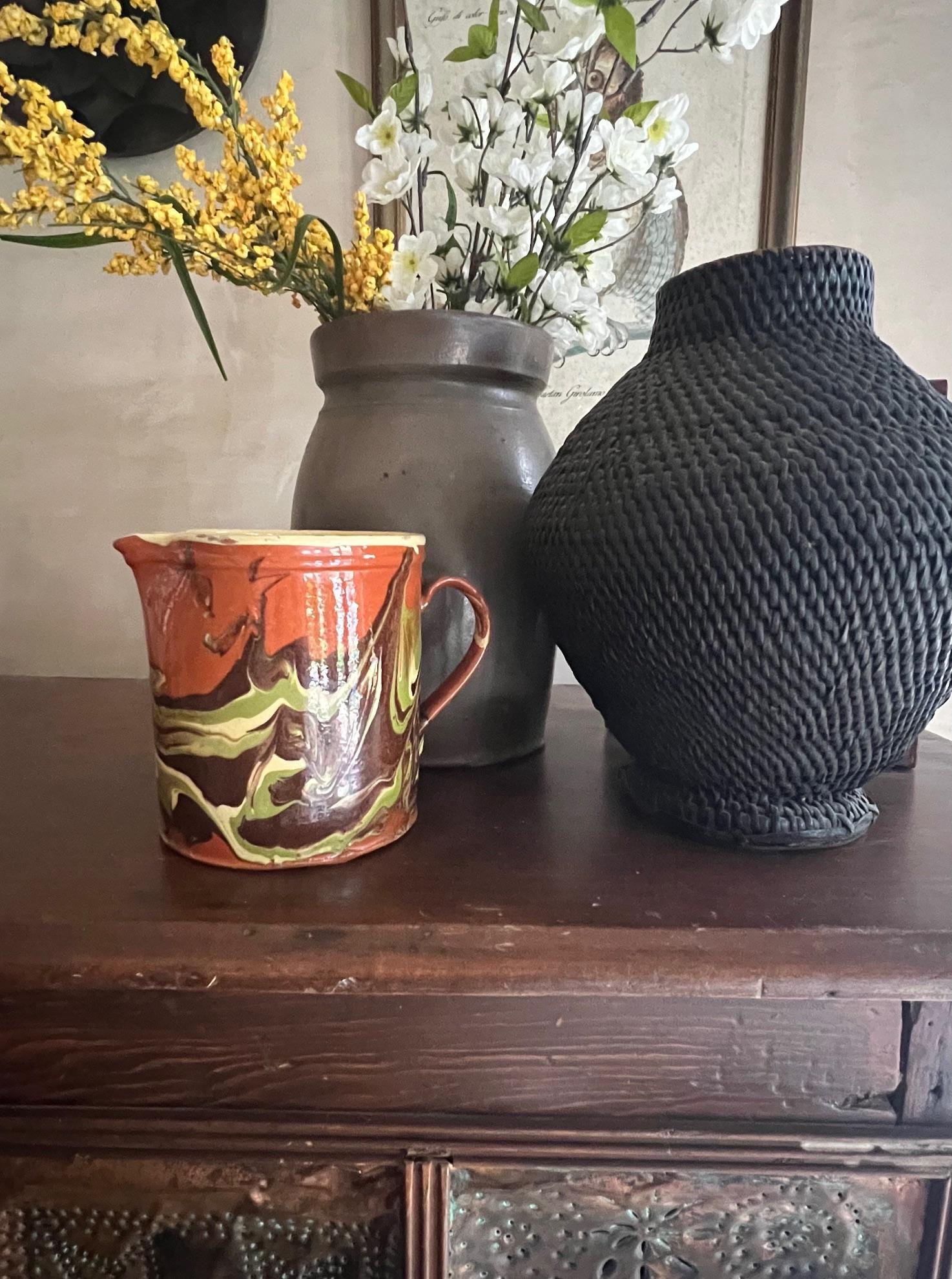 Pichet en céramique Jaspe en terre cuite avec un motif marbré d'orange brûlé, de vert et de jaune beurre. Ce pichet a été fabriqué en Savoie à la fin du 19e siècle. Il est marqué d'un 8 sur le fond.

Les poteries de MEAN sont typiquement des