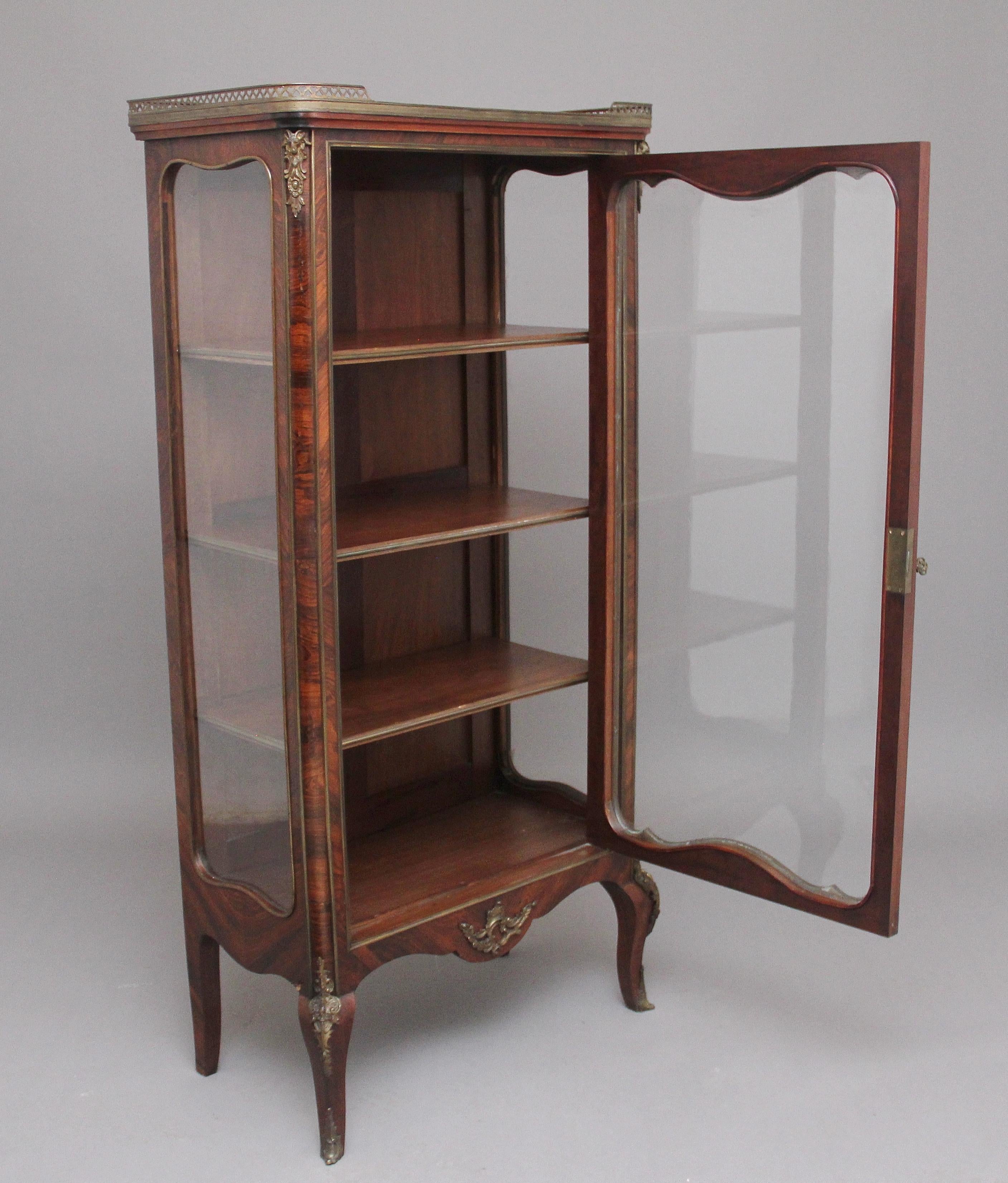 19th century French Kingwood display cabinet, having a rouge marble top with a brass gallery, the single door at the front having lovely shaped glass and this is the same at the sides of the cabinet, the door front inlaid with floral and shell