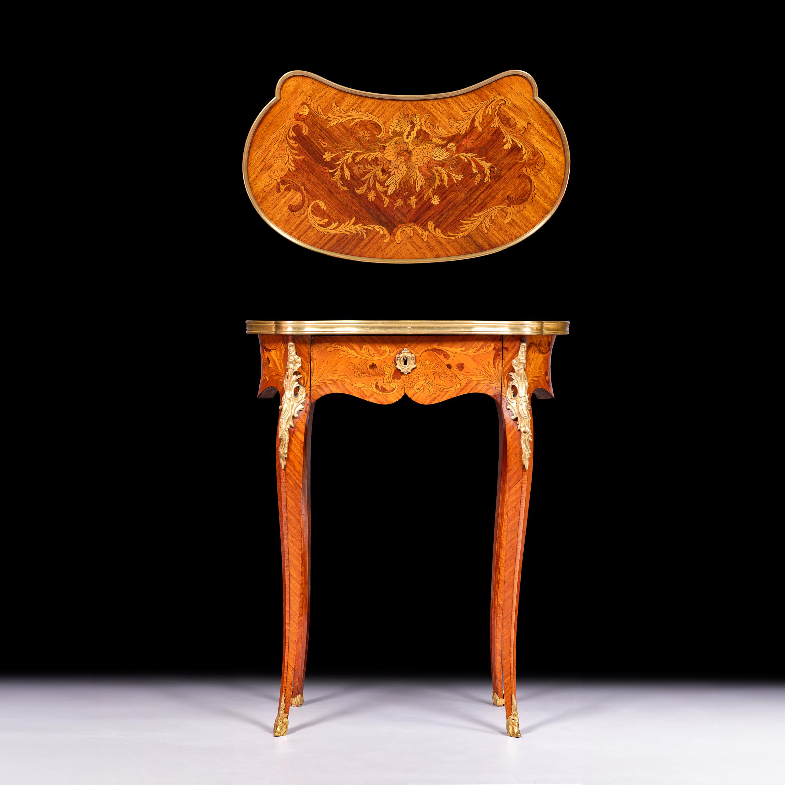 A very fine and elegant kidney shaped side / occasional table, raised by four delicately scrolled cabriole legs the kidney-shaped table is fitted with a small central lockable drawer. The table top is decorated with a pattern marquetry, while the