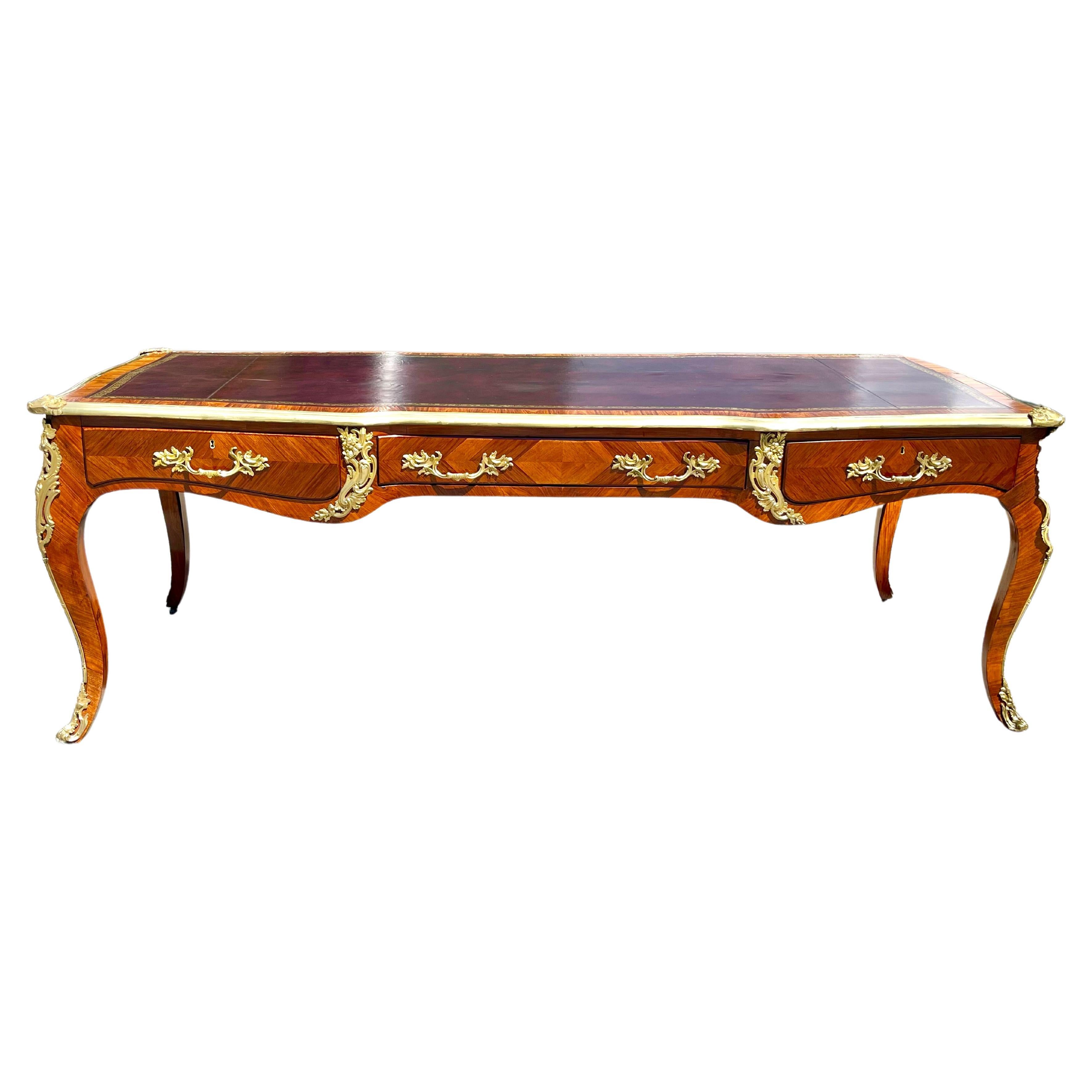 19th century French kingwood Bureau plat writing desk. Beautiful Louis XV Form. Lacquered Bronze Mounts are original. Grand proportion. Embossed Plum leather.

