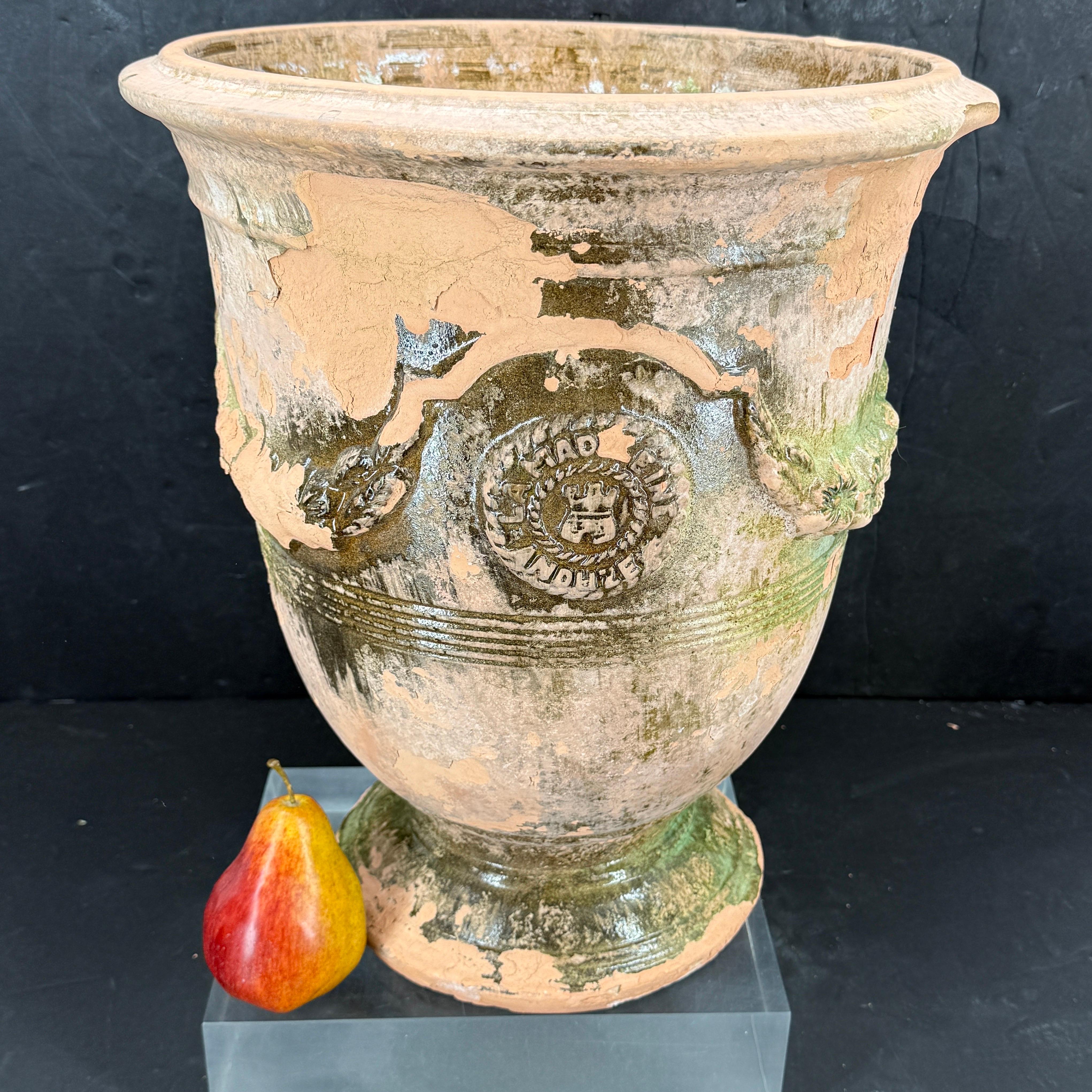 Tall La Madeleine Planter from Anduze, France featuring graceful floral garlands and two badges. Horizontal reeding adds texture, while the flared rim and pedestal base give it a stately presence. In modern interiors and gardens, this urn serves as