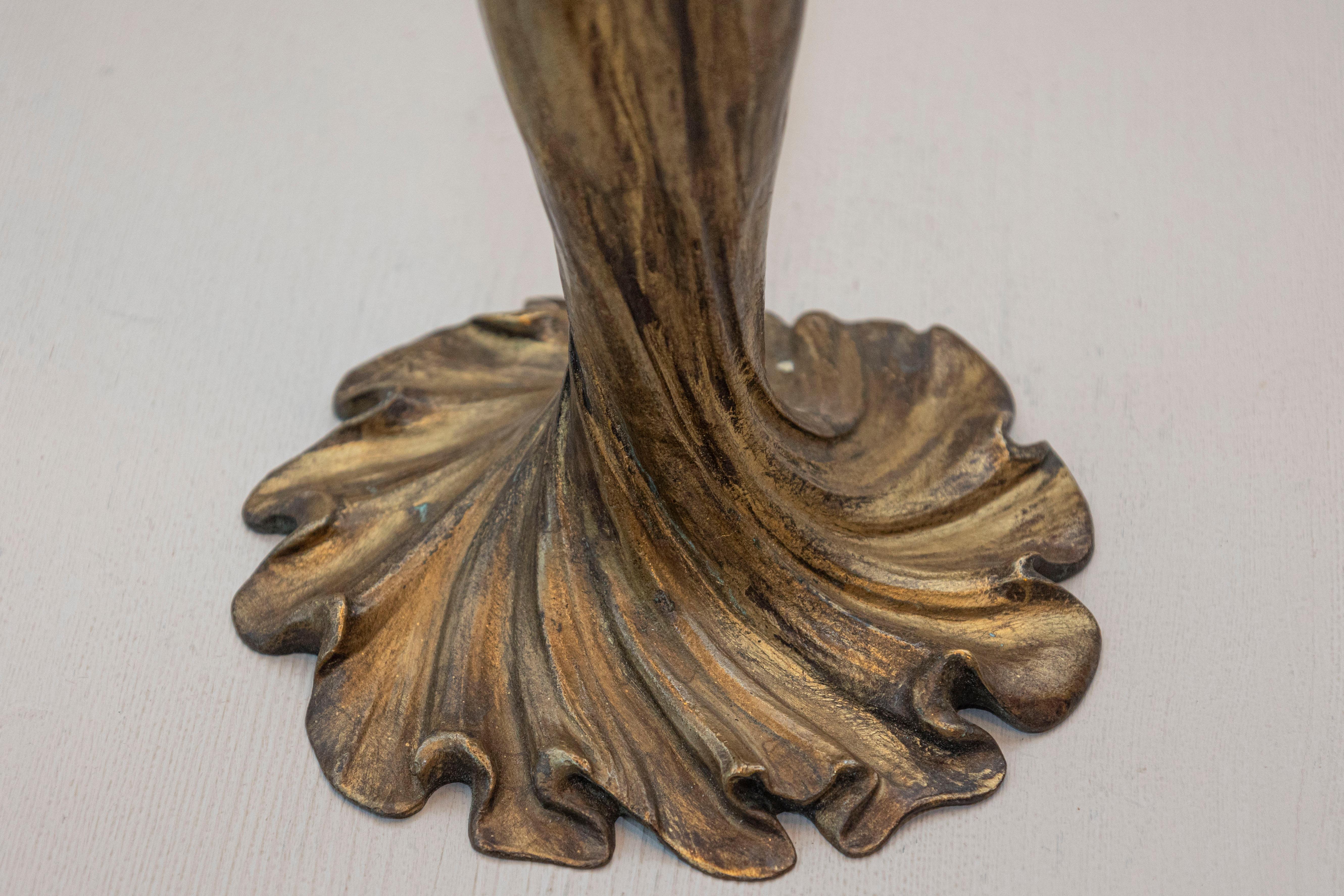 Esta lámpara francesa del siglo XIX es un cautivador ejemplo de arte escultórico y diseño funcional. La lámpara presenta una figura bellamente detallada de una mujer con un vestido vaporoso, esculpida en una pose naturalista que desprende gracia y
