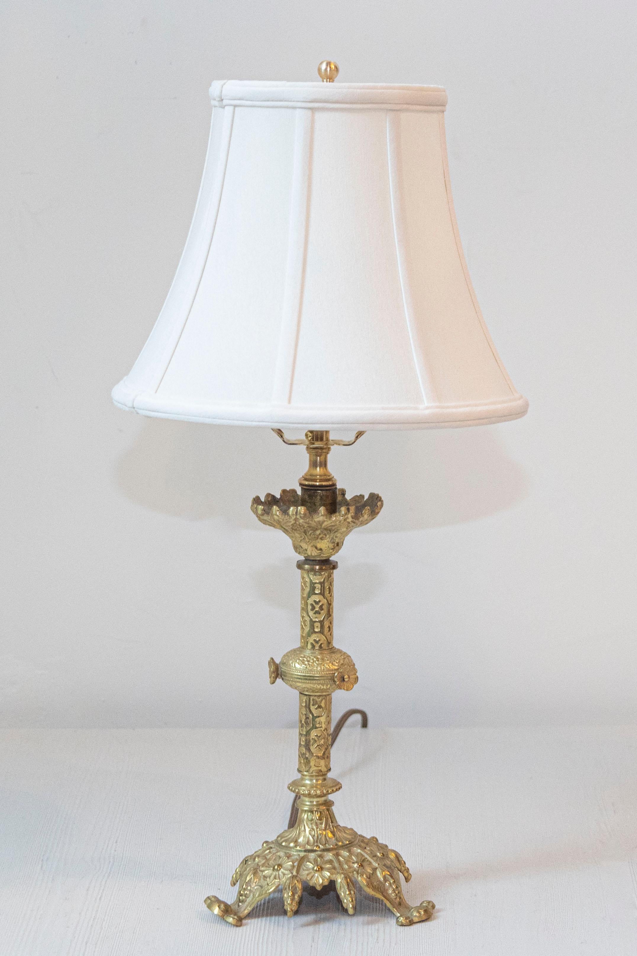 Esta lámpara de madera dorada del siglo XX desprende una elegancia atemporal con su diseño clásico y su dorado original en pan de oro, que se conserva en excelente estado. La base esculpida presenta una elegante columna retorcida, que añade