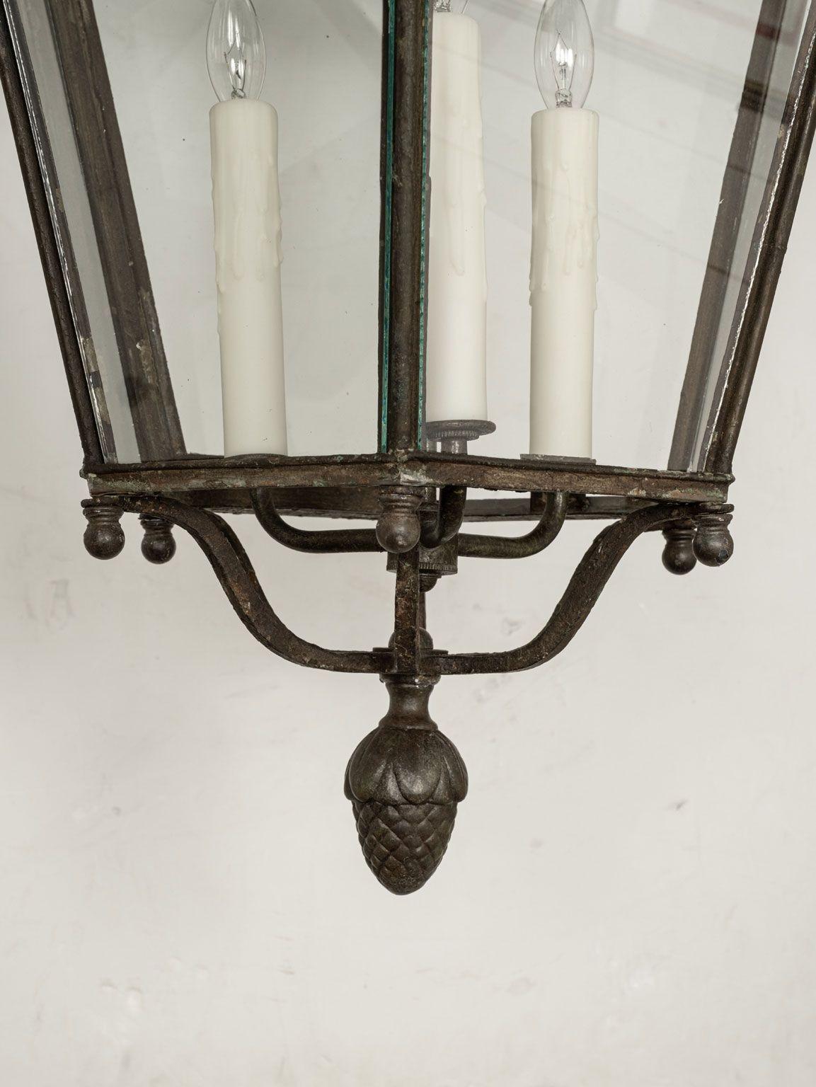 19th century French lantern in tole, iron and glass. Repousse decoration. Circa 1860-1899. Newly wired with a three candelabra socket drop-cluster. Includes chain and a canopy (listed height does not include chain).