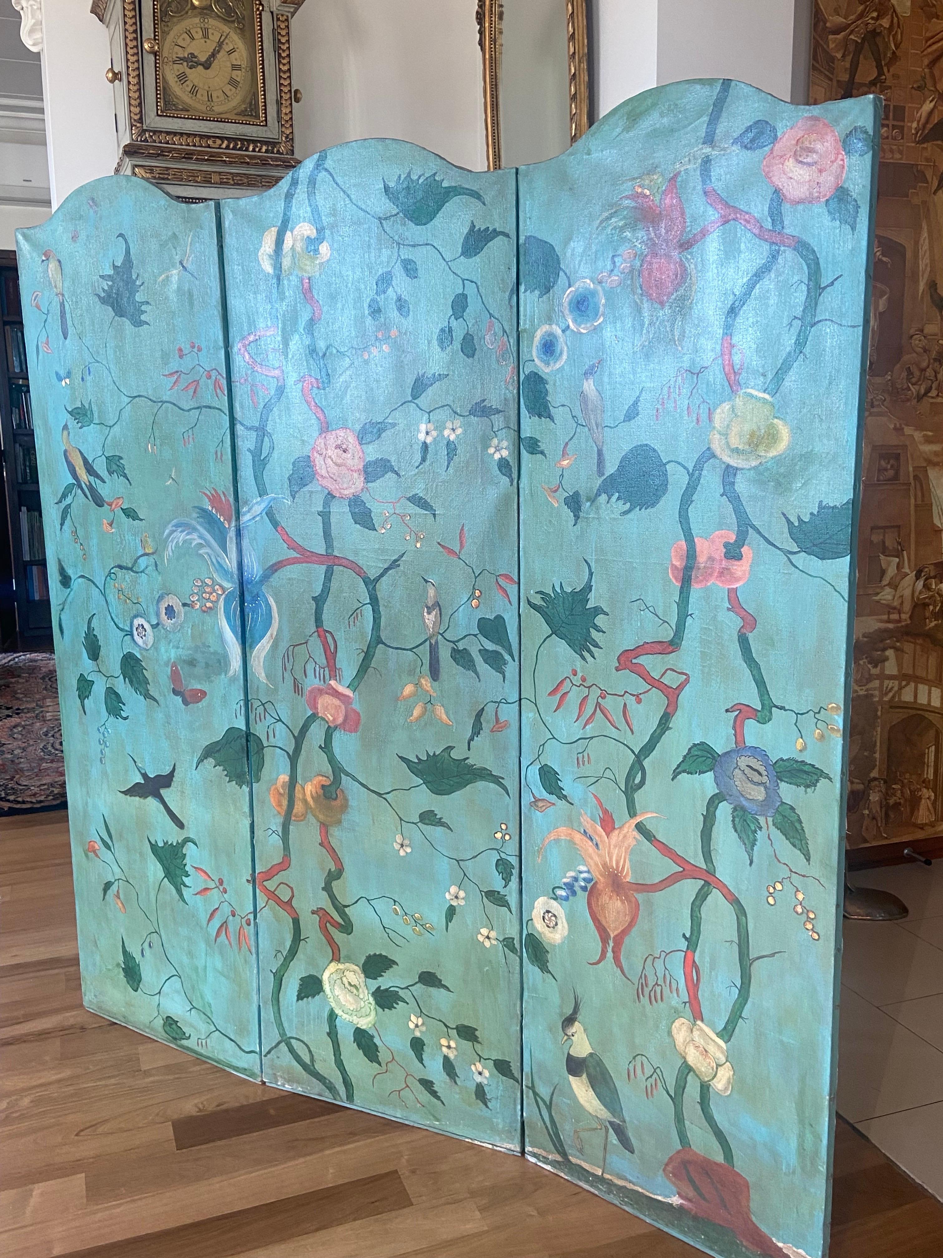 Lovely large French room divider or screen with three leaves in canvas hand painted in vivid colors with birds and foliage scrolls on blue base, after a pattern from a wall canvas preserved in the Château de Talcy in France. The piece was made in